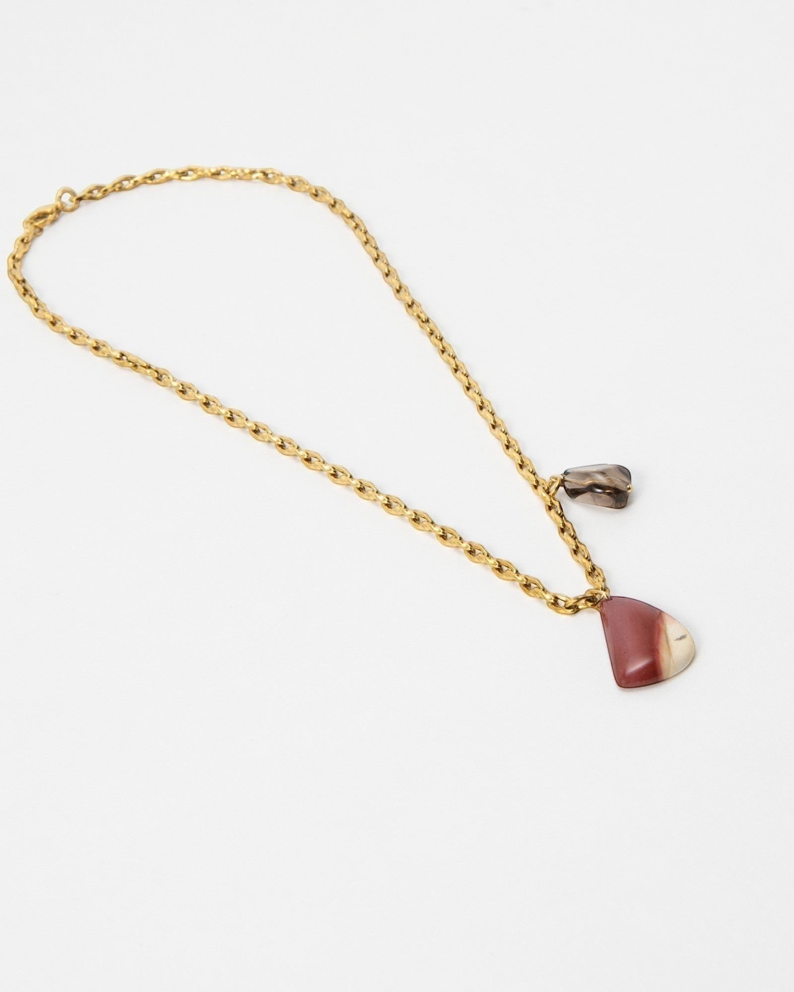 Elsita Jewelry Ember necklace featuring a gold chain with a polished red and cream stone pendant and small charm