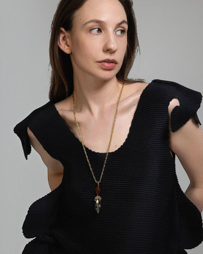 Model wearing Elsita Jewelry Flame necklace with clear quartz and red agate pendant on a gold chain