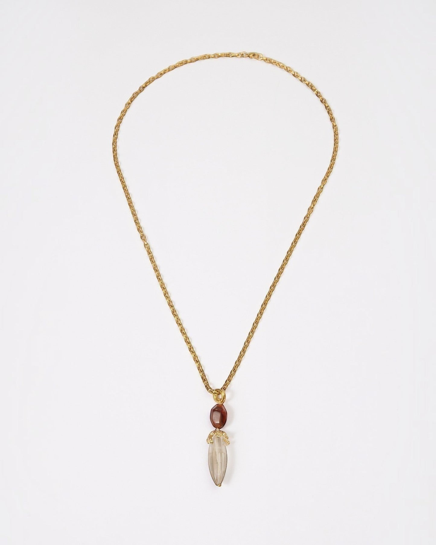 Elsita Jewelry Flame necklace featuring a raw clear quartz pendant and red agate on a textured gold chain.