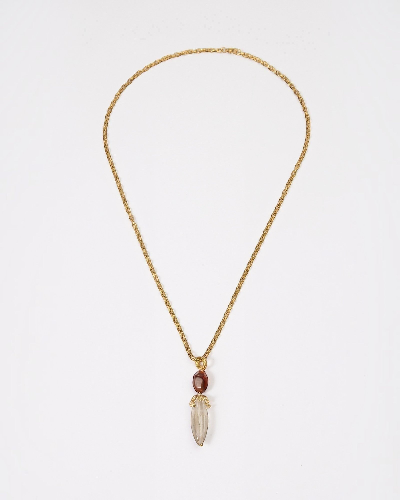 Elsita Jewelry Flame necklace featuring a raw clear quartz pendant and red agate on a textured gold chain.