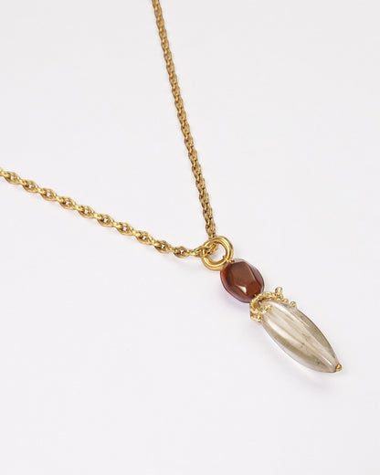 Elsita Jewelry Flame necklace featuring a clear quartz pendant and red agate on a textured gold stainless steel chain.