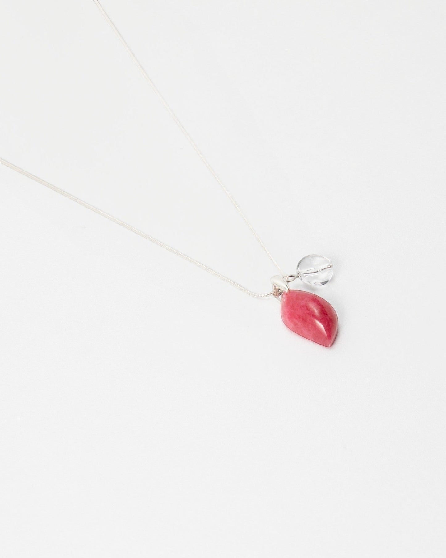 Elsita Jewelry Fuchsia necklace featuring a pink teardrop-shaped stone pendant and a small clear crystal charm.