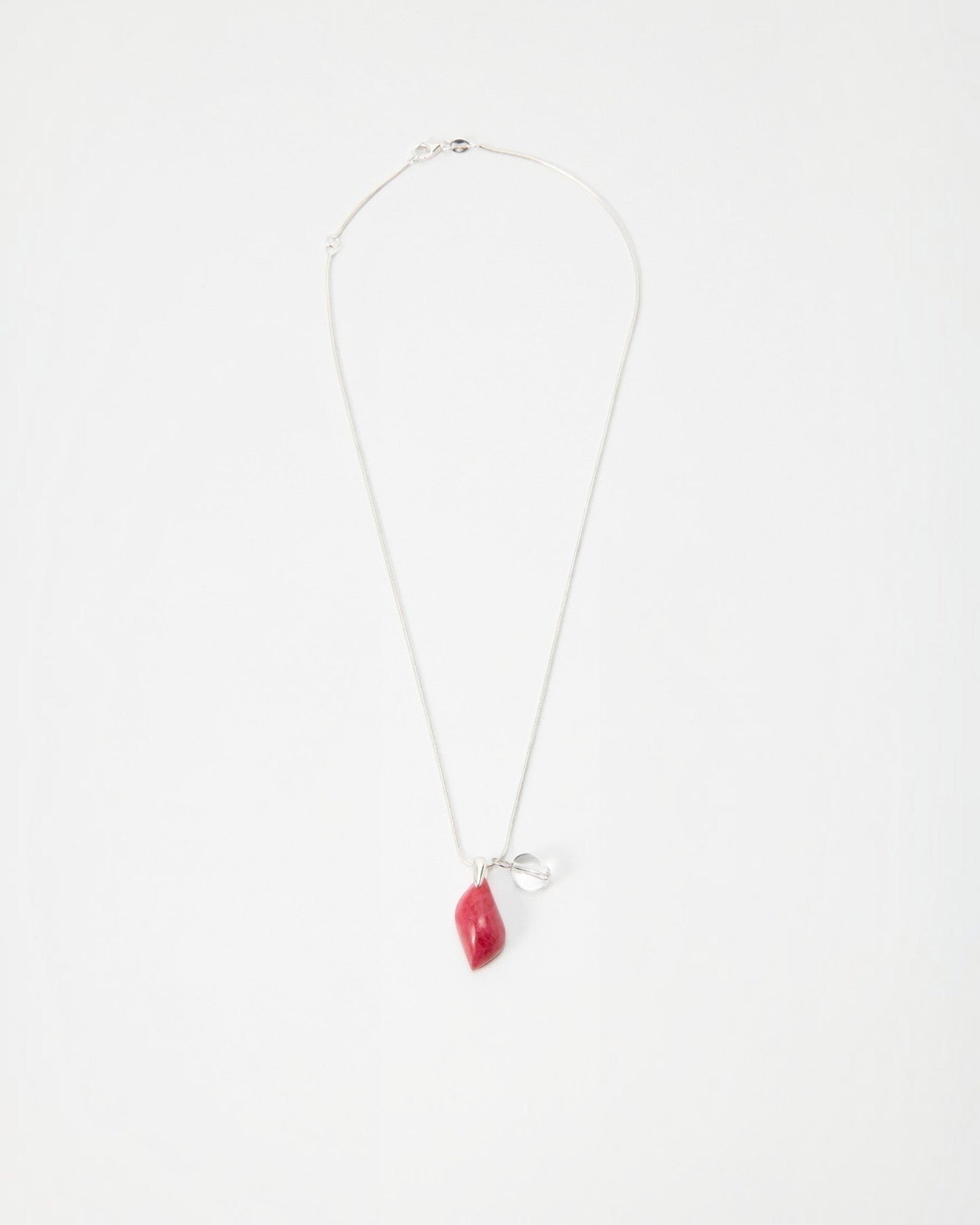 Elsita Jewelry Fuchsia necklace featuring a small red organic-shaped pendant and silver charm on a delicate chain