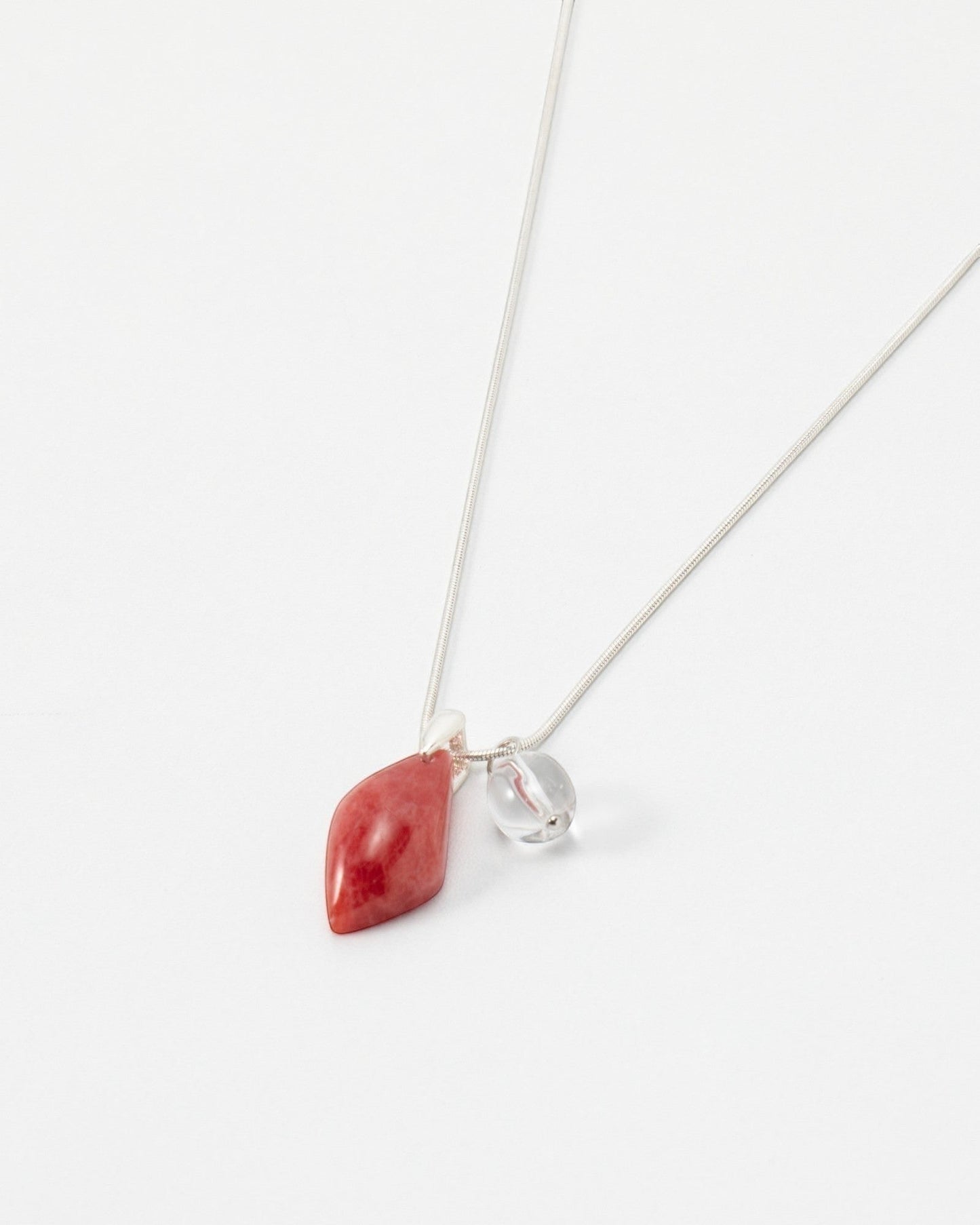 Elsita Jewelry Fuchsia necklace featuring a teardrop-shaped red stone and a small clear bead on a delicate silver chain.
