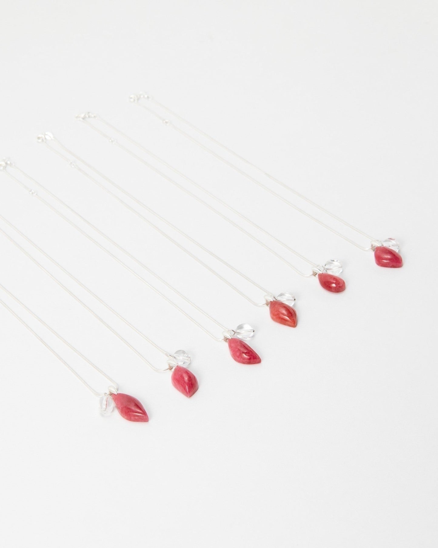 Elsita Jewelry Fuchsia necklaces featuring delicate silver chains with small red teardrop pendants on white background