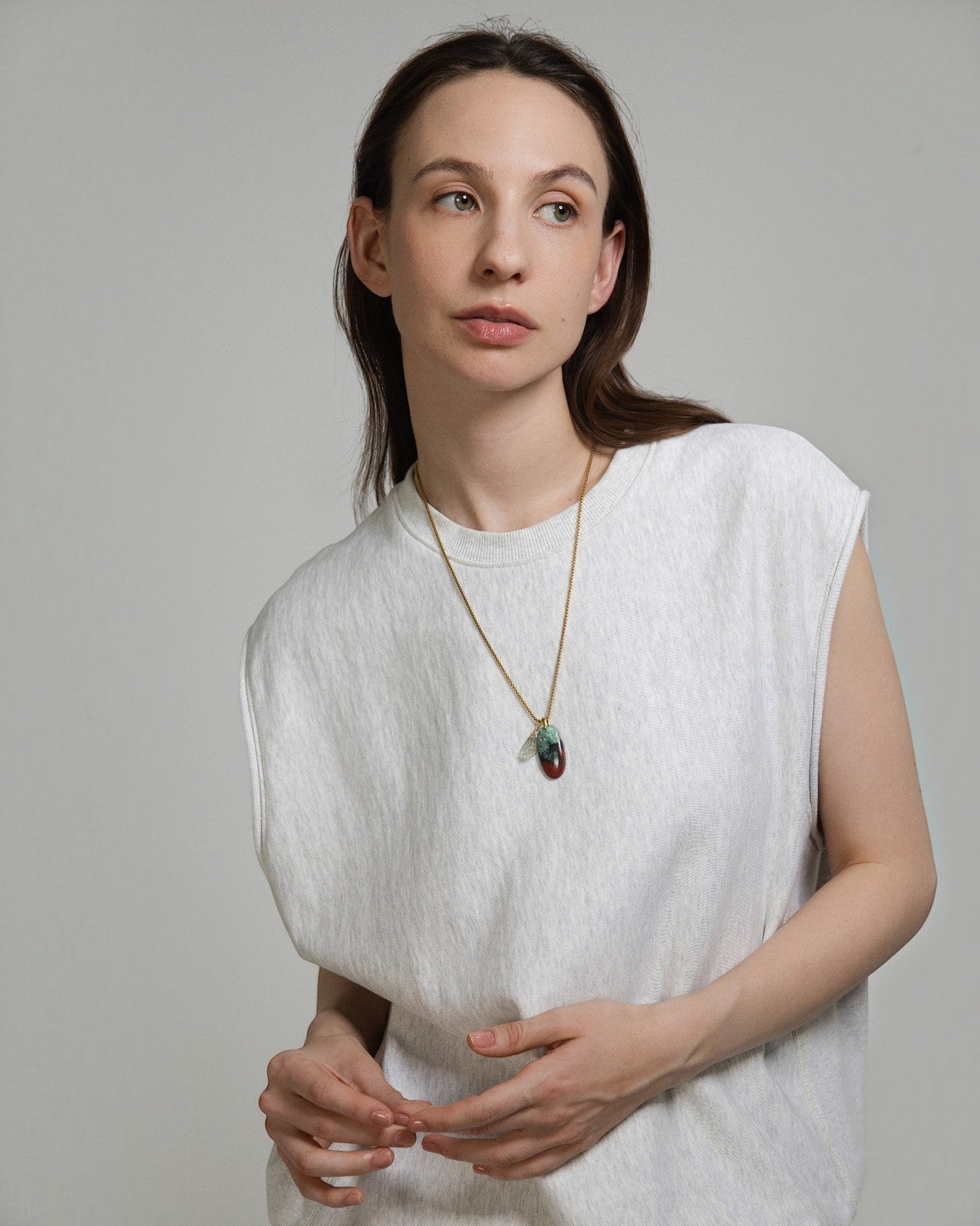 Model wearing an Elsita Jewelry Horizon III necklace featuring a Sonora sunset stone and green quartz pendant.