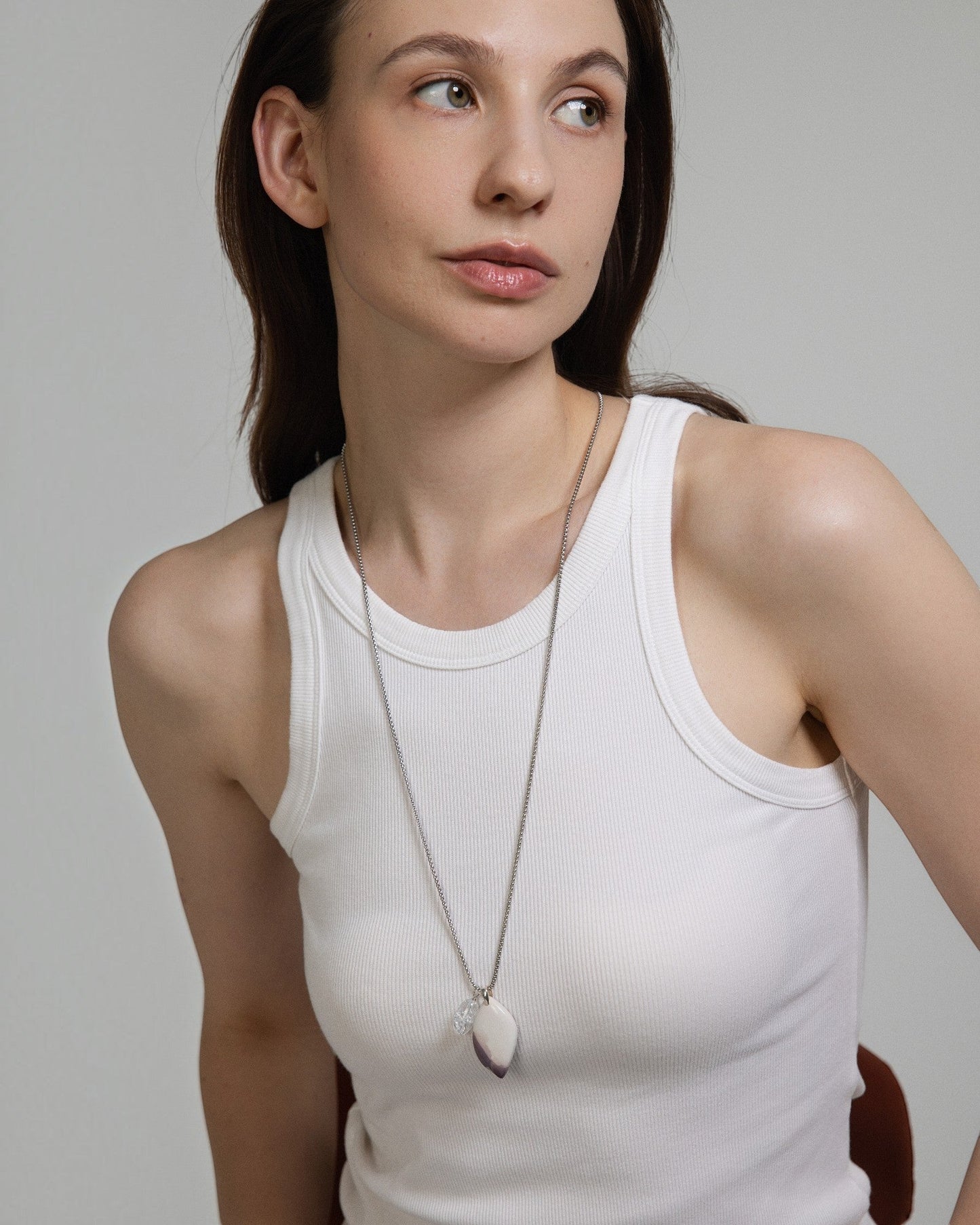 Model wearing an Elsita Jewelry Hyacinth Jasper pendant necklace with a clear quartz accent on a sterling silver chain.