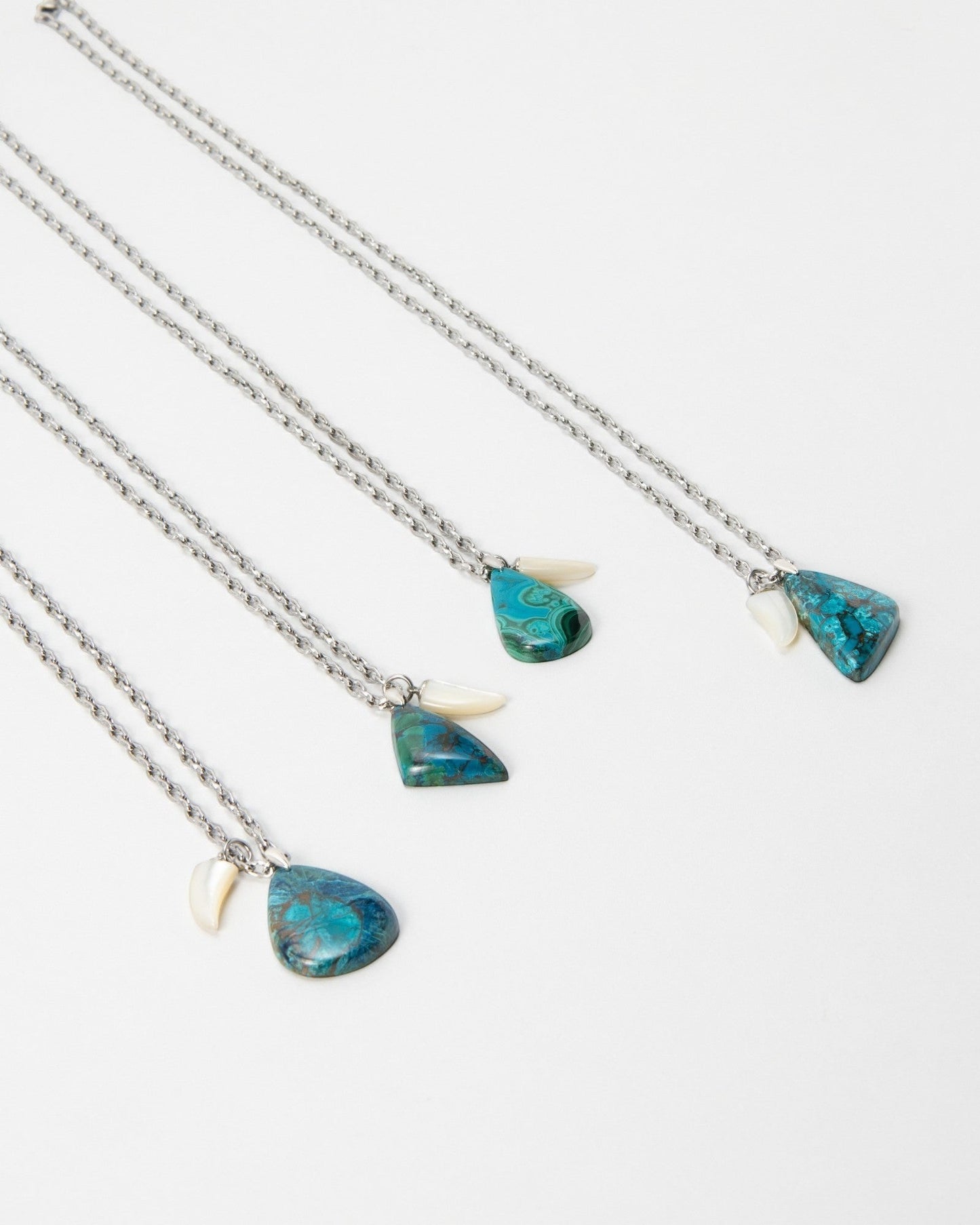 Elsita Jewelry Lagoon I necklaces featuring teardrop-shaped blue chrysocolla stones and small white shell accents