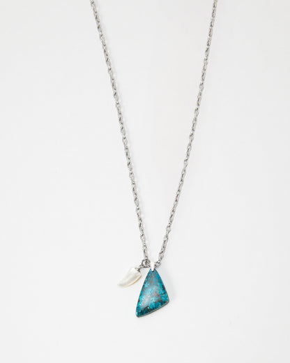 Elsita Jewelry Lagoon I necklace featuring a triangular blue stone pendant and a small white horn charm on a silver chain