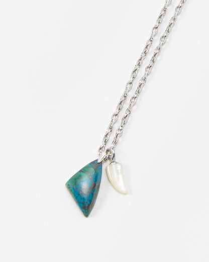 Elsita Jewelry Lagoon III necklace featuring a silver chain with a blue triangular stone pendant and a white shell charm