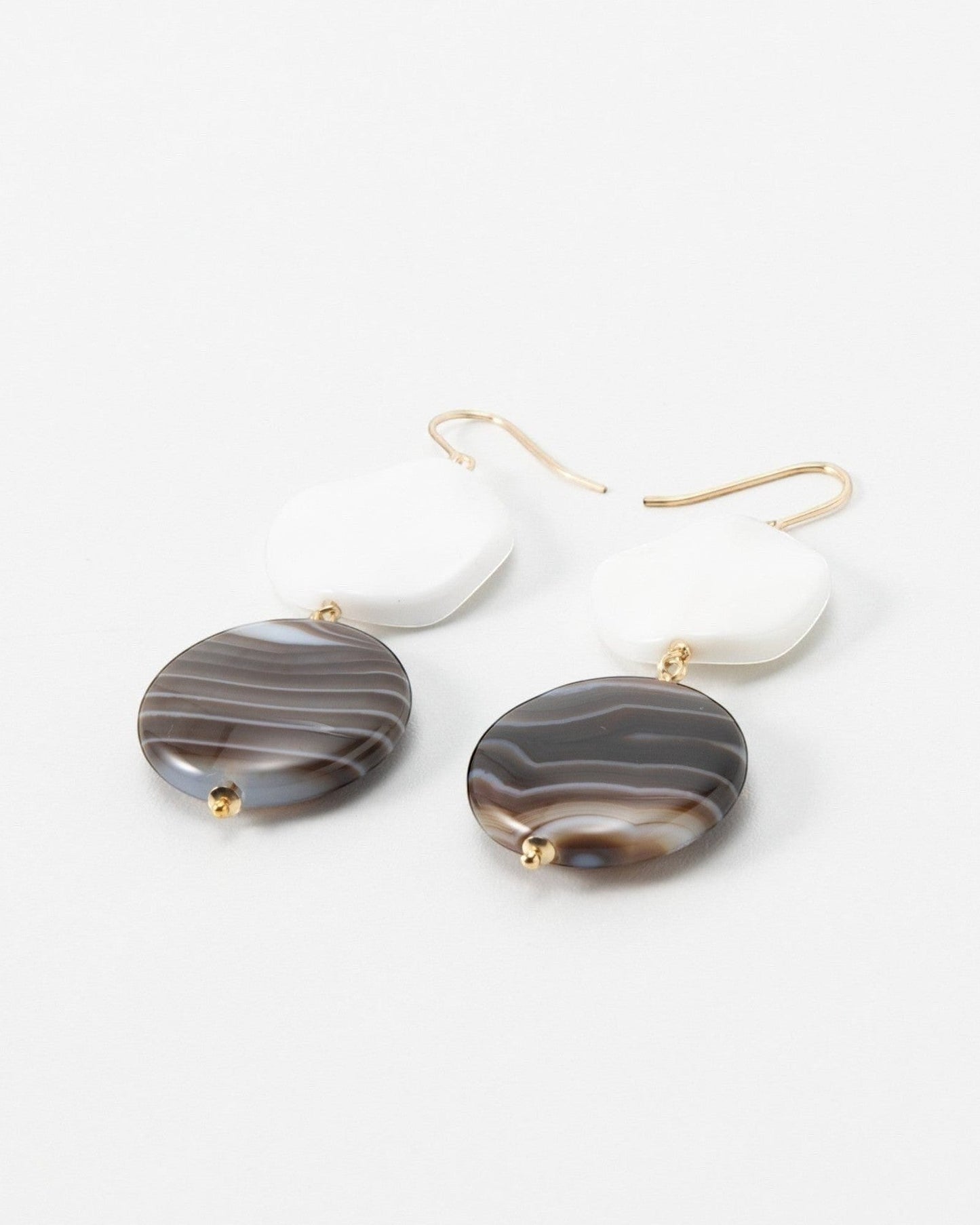 Elsita Jewelry Macchiato earrings featuring white geometric shapes and brown banded agate stone drops on gold hooks.
