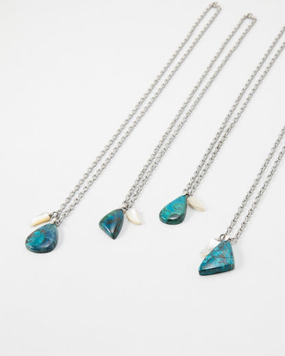 Four Elsita Jewelry Lagoon III necklaces featuring blue malachite pendants and small white shell accents on silver chains