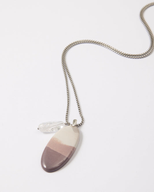 Elsita Jewelry Mauve I necklace featuring a gradient Hyacinth Jasper pendant and clear quartz on a stainless steel chain.