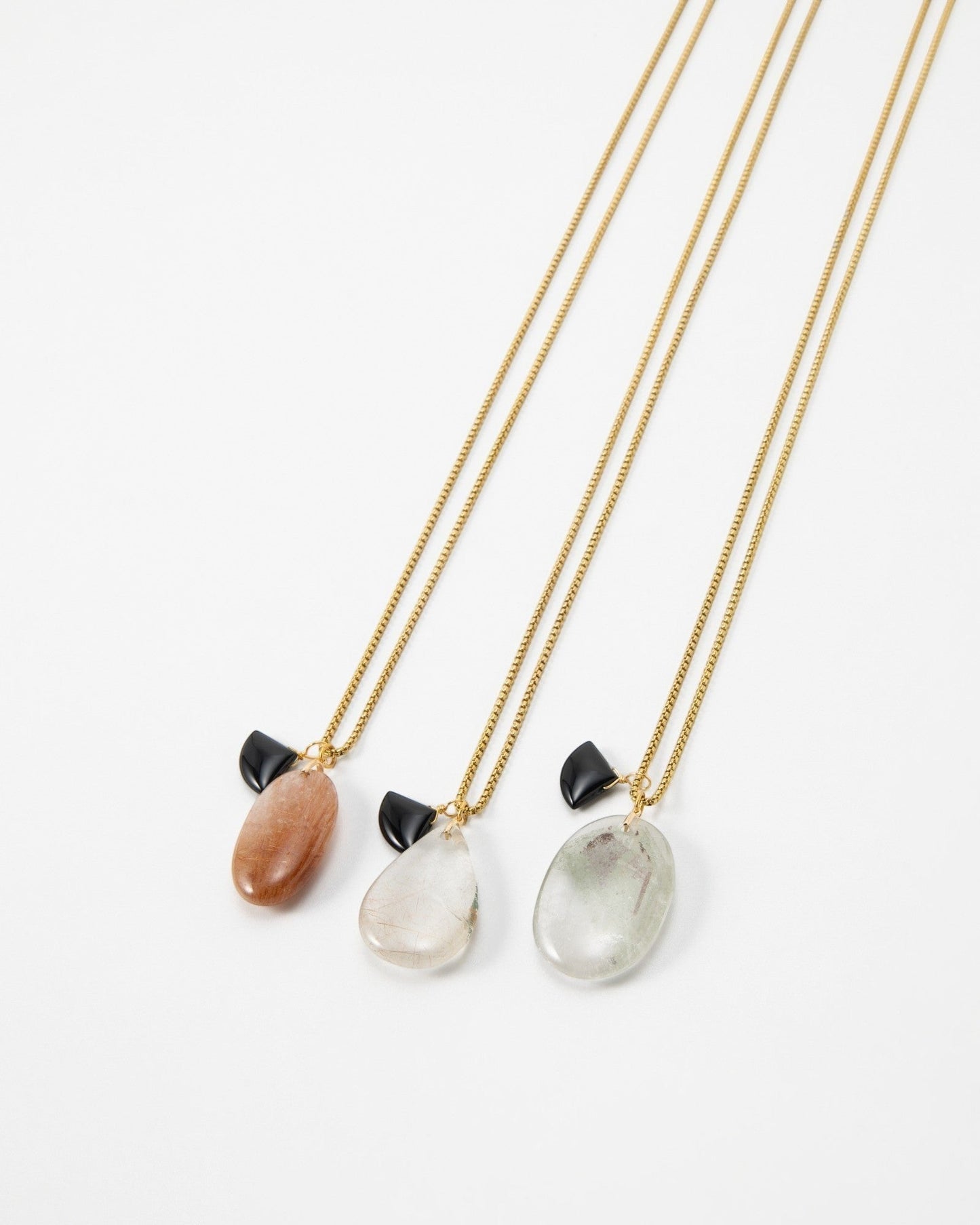 Elsita Jewelry Mist I necklaces featuring polished gemstone pendants on gold chains with small black accents