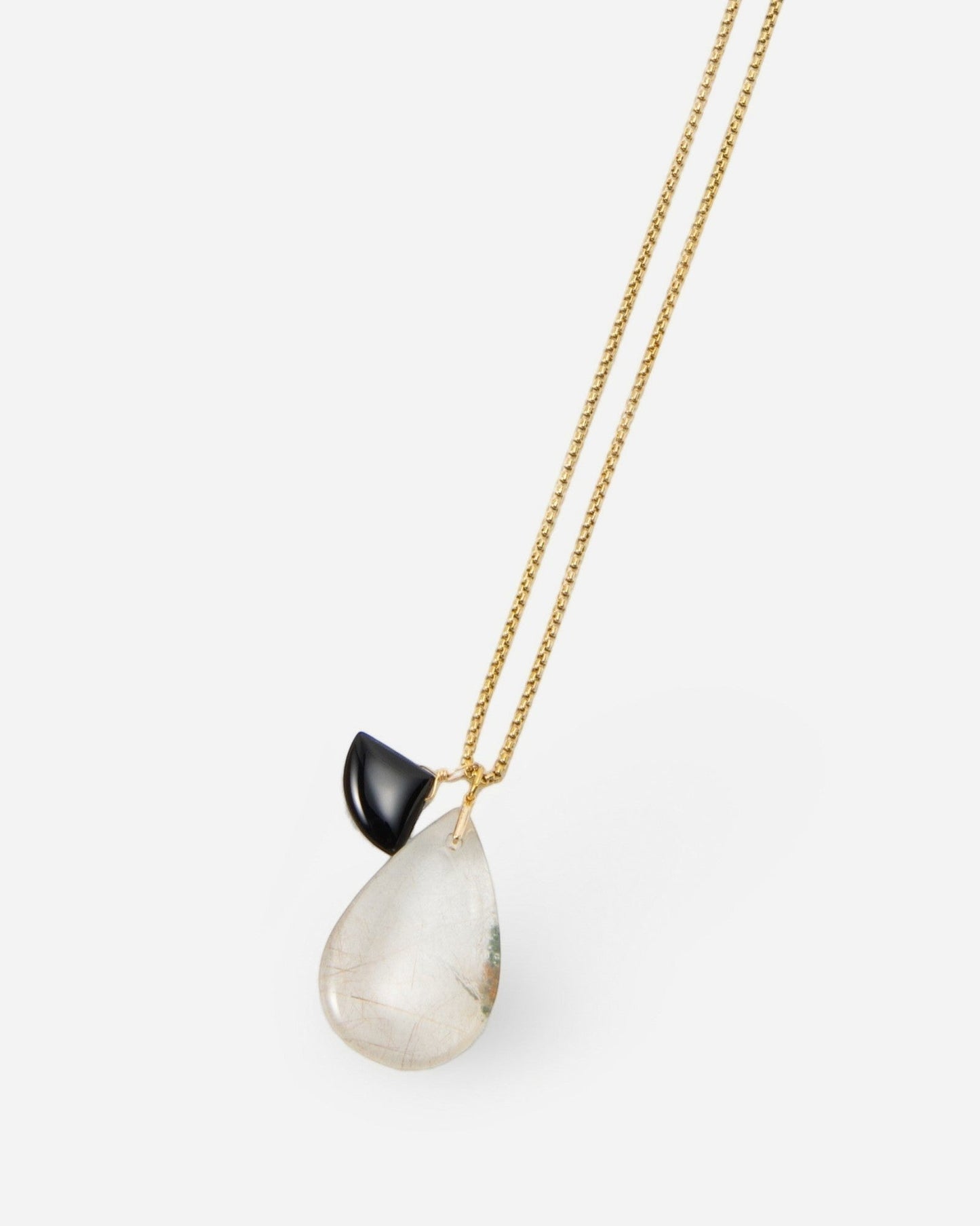 Elsita Jewelry Mist I necklace featuring a delicate gold chain with a teardrop-shaped clear stone and black accent.