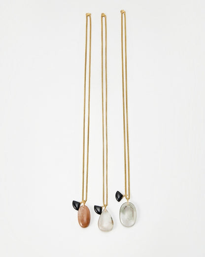Elsita Jewelry Mist II necklaces featuring gold chains with oval stone pendants and small black accents