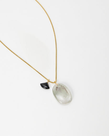 Elsita Jewelry Mist III necklace featuring a gold chain with a clear quartz pendant and a small black accent stone