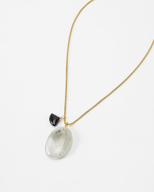 Elsita Jewelry Mist III necklace featuring a large oval translucent stone and a small black charm on a gold chain.