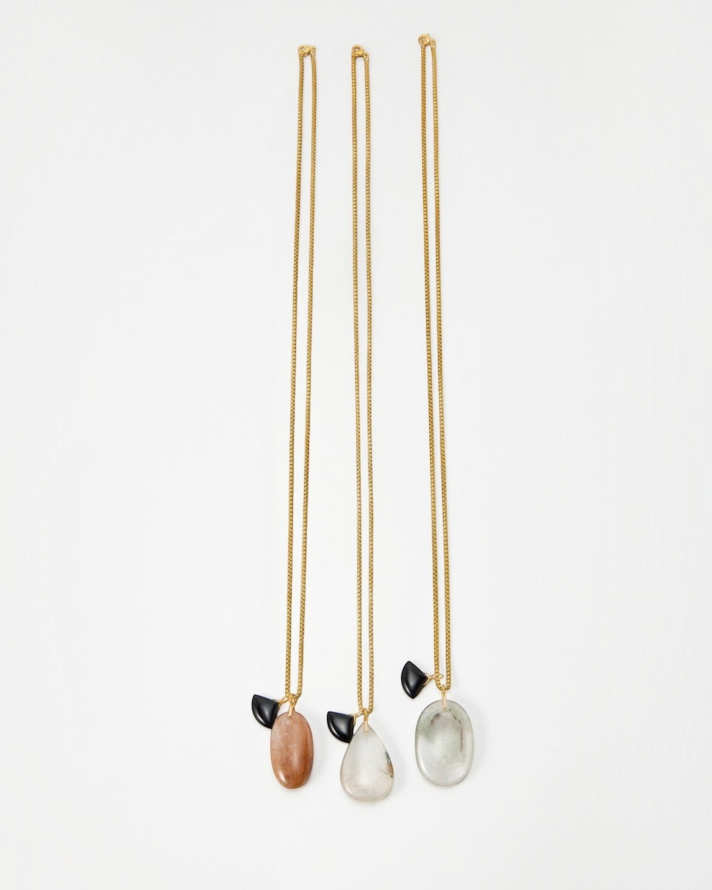 Elsita Jewelry Mist III set of three gold chain necklaces featuring unique teardrop-shaped stone pendants and black accents