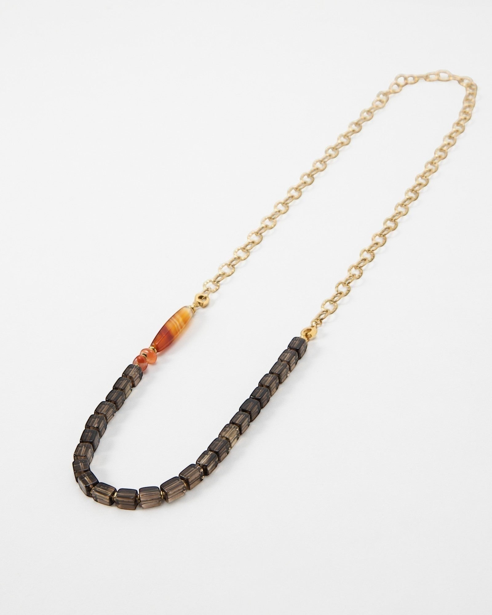 Elsita Jewelry Mosaic necklace featuring dark square beads, a striped carnelian accent, and a gold chain link.