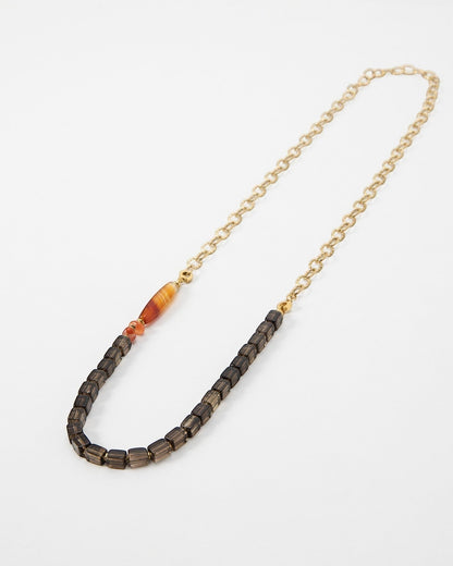 Elsita Jewelry Mosaic necklace featuring dark square beads, a striped carnelian accent, and a gold chain link.