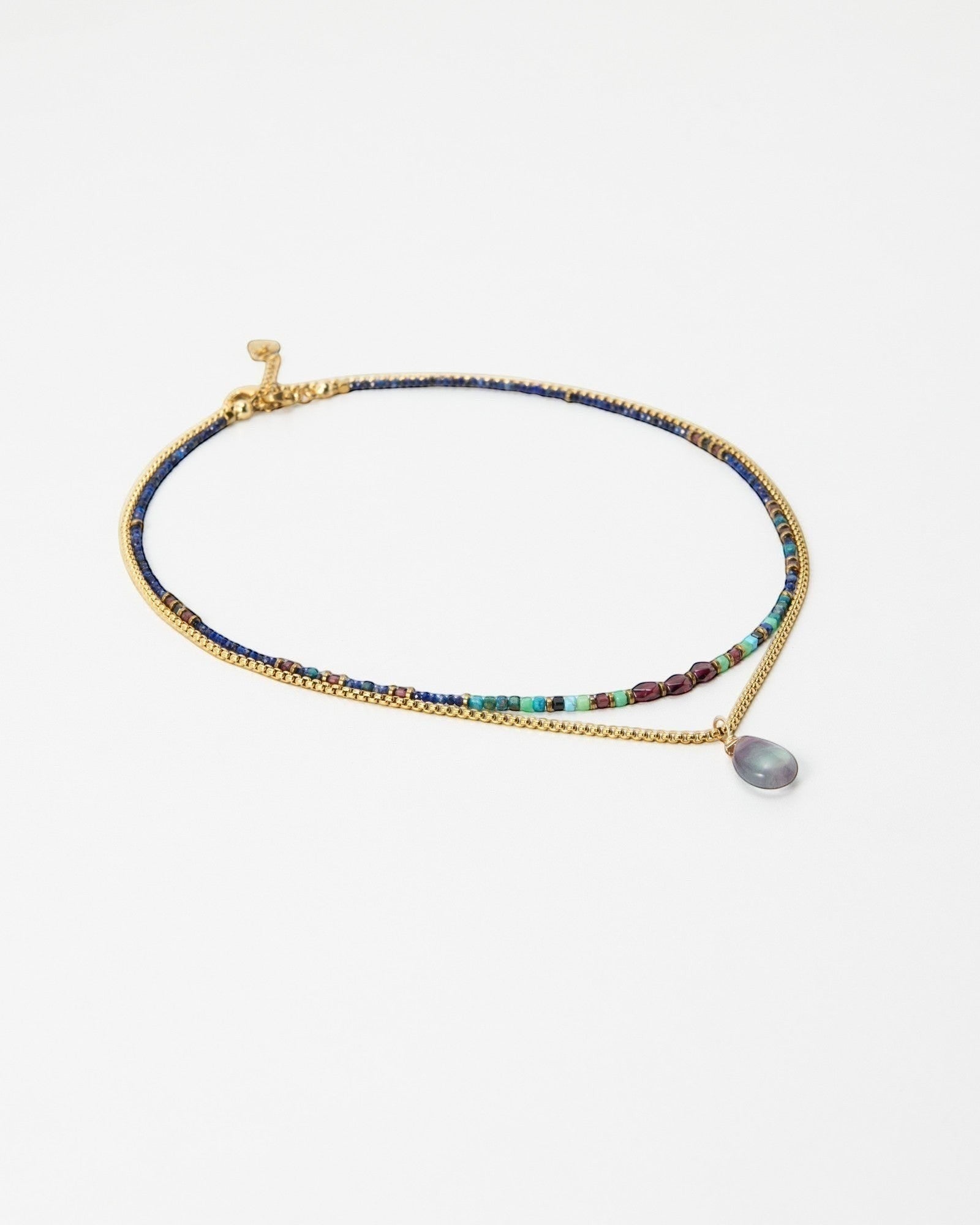 Elsita Jewelry Nomad layered necklace featuring a beaded strand and a gold chain with a teardrop pendant.