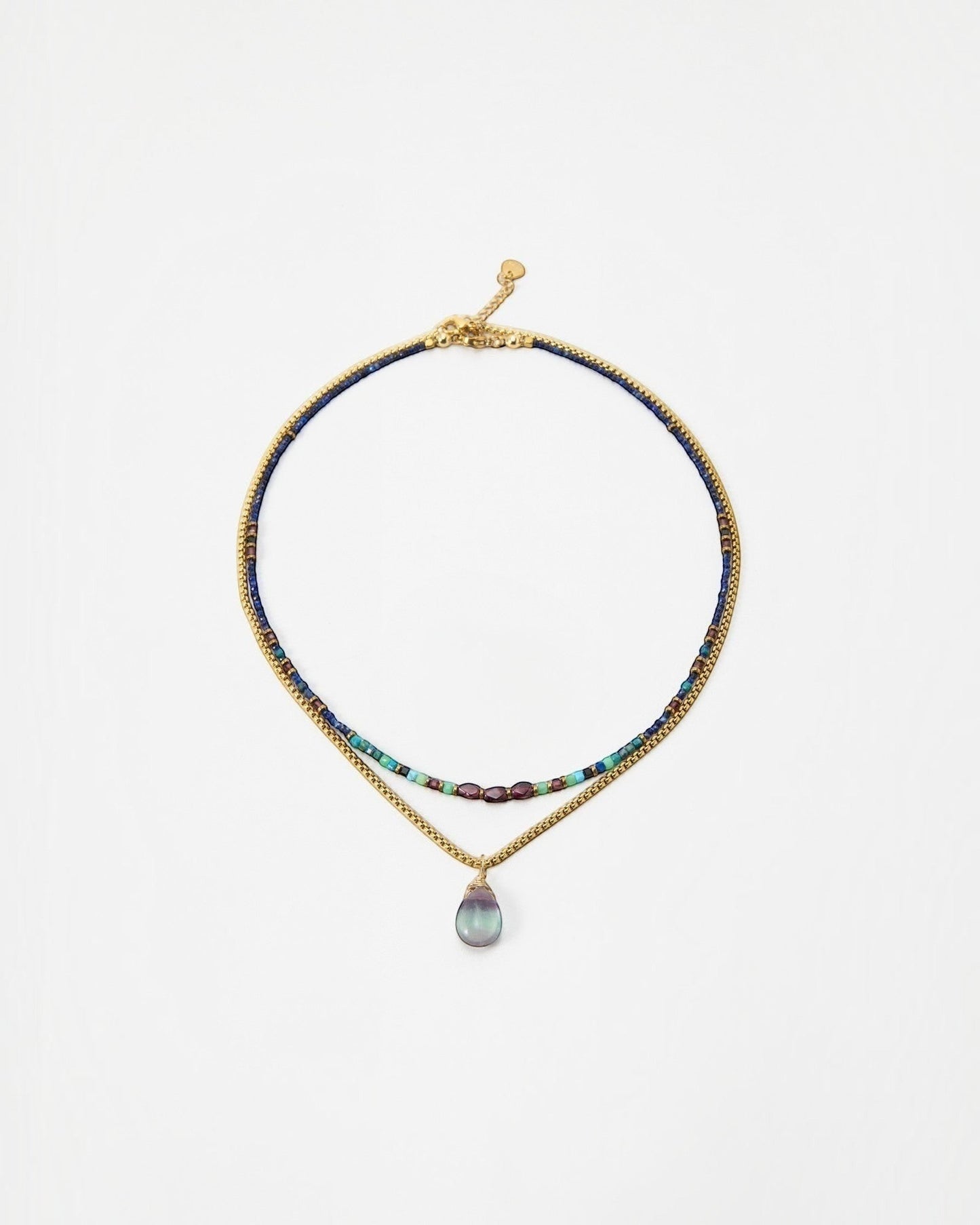 Elsita Jewelry Nomad layered necklace with blue beads, gold chain, and a teardrop gemstone pendant.