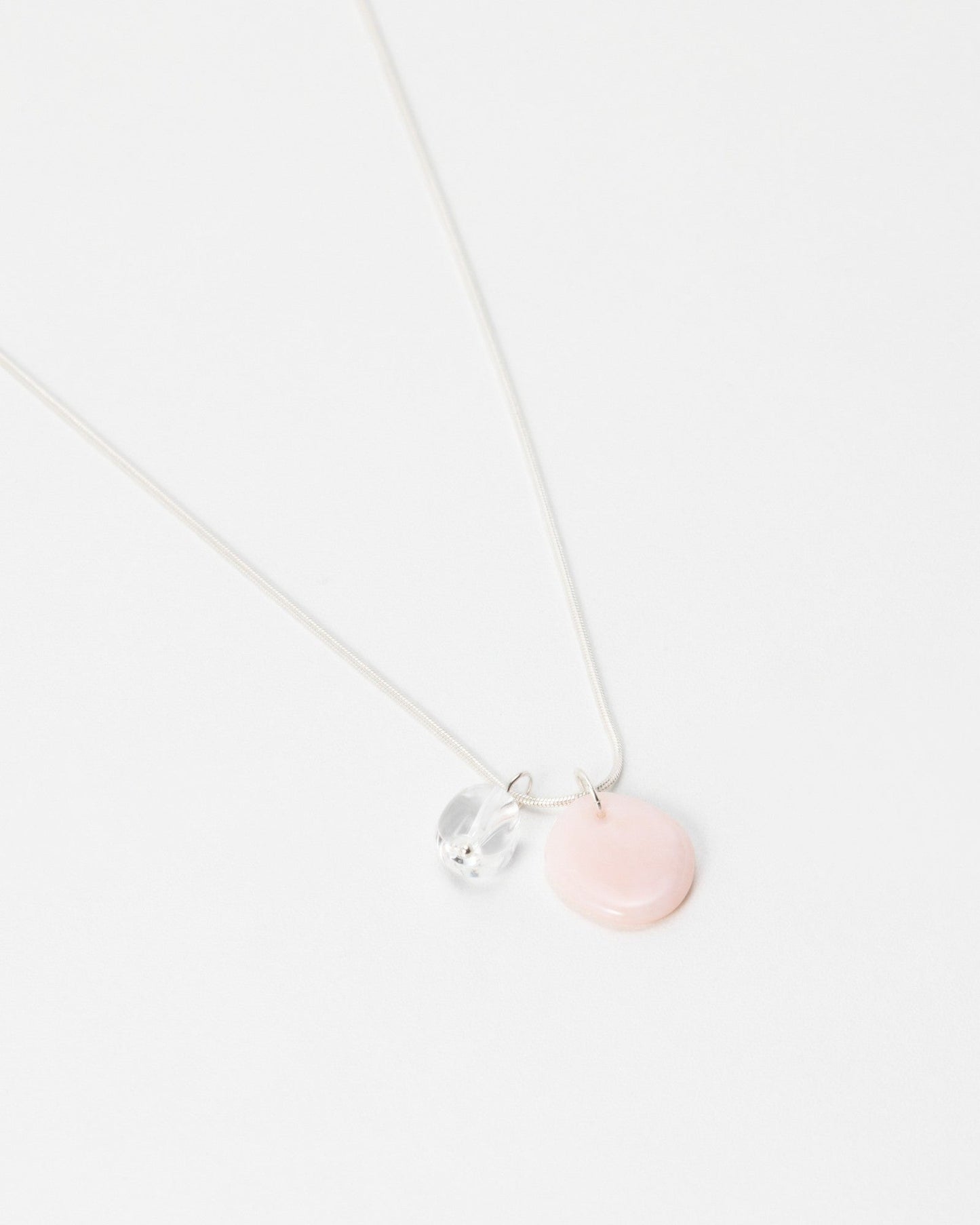 Elsita Jewelry Petal Clear necklace featuring a delicate silver chain with a pink disc and clear crystal charm