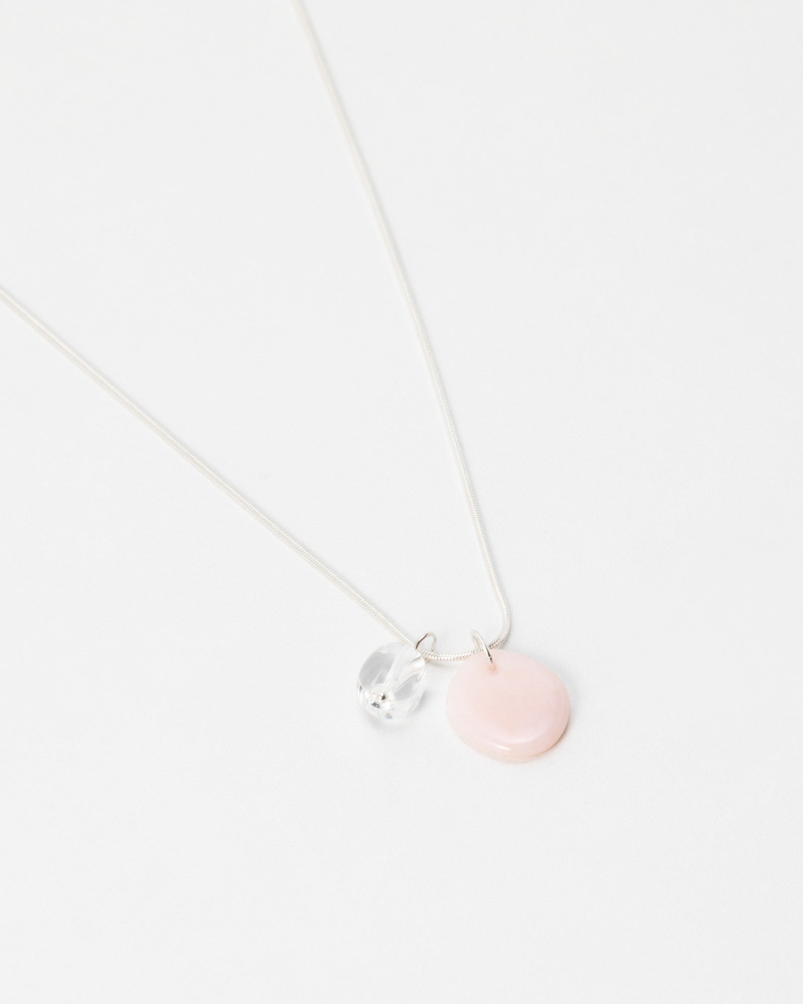 Elsita Jewelry Petal Clear necklace featuring a delicate silver chain with a pink disc and clear crystal charm