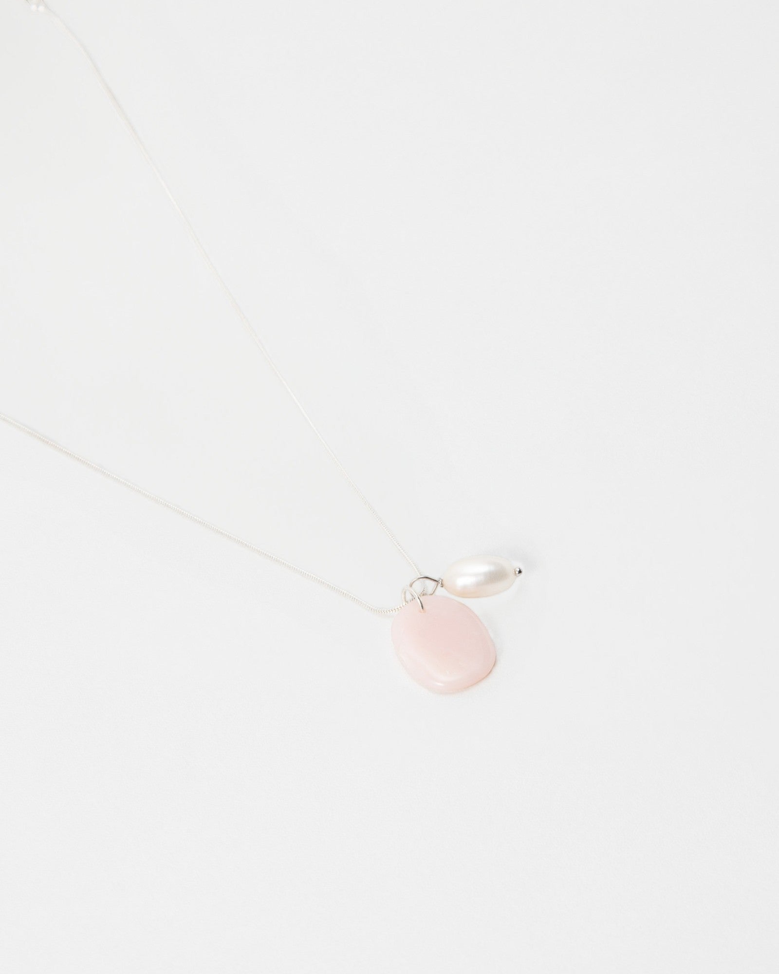 Elsita Jewelry Petal Pearl necklace featuring a delicate silver chain with a pink stone and white pearl pendant