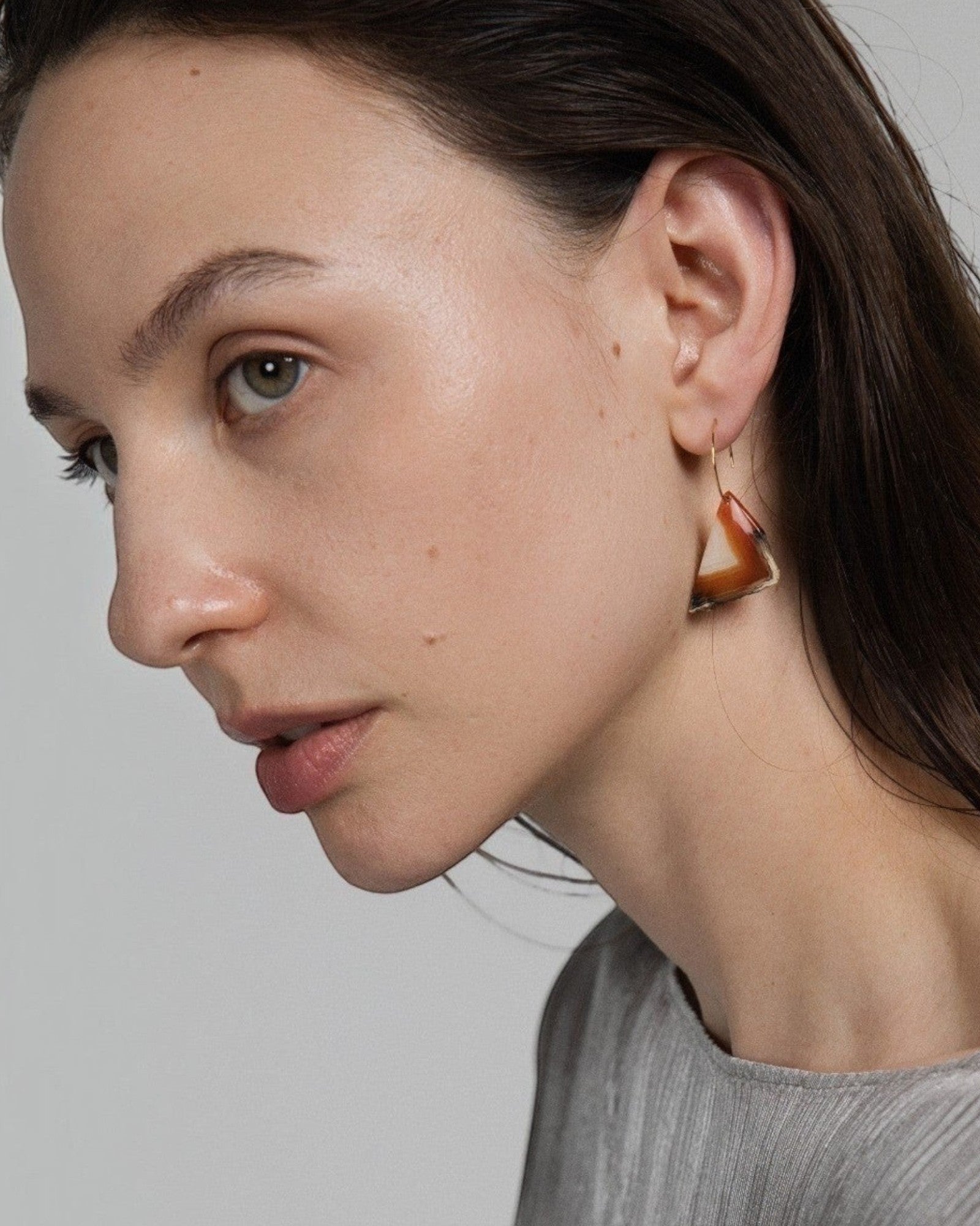 Elsita Jewelry Wild 13 raw Indonesian agate slice earring on a 14K gold-filled hoop worn by a model in profile.