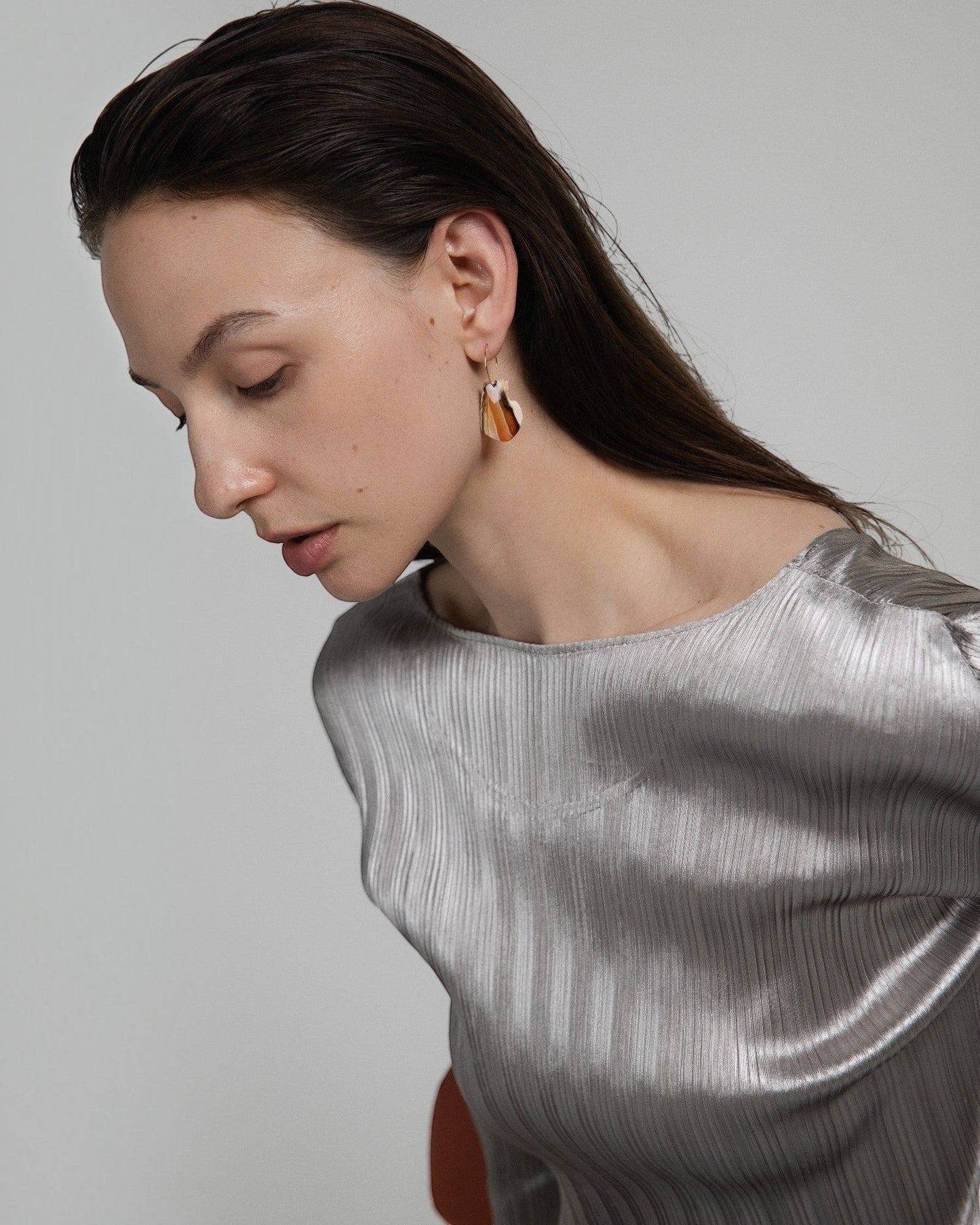 Model wearing Elsita Jewelry Wild 1 raw Indonesian agate earrings on 14K gold-filled hoops with earthy banding.
