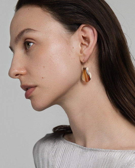 Elsita Jewelry Wild 1 raw Indonesian agate slice earrings on 14K gold-filled hoops worn by a model in a silver top.