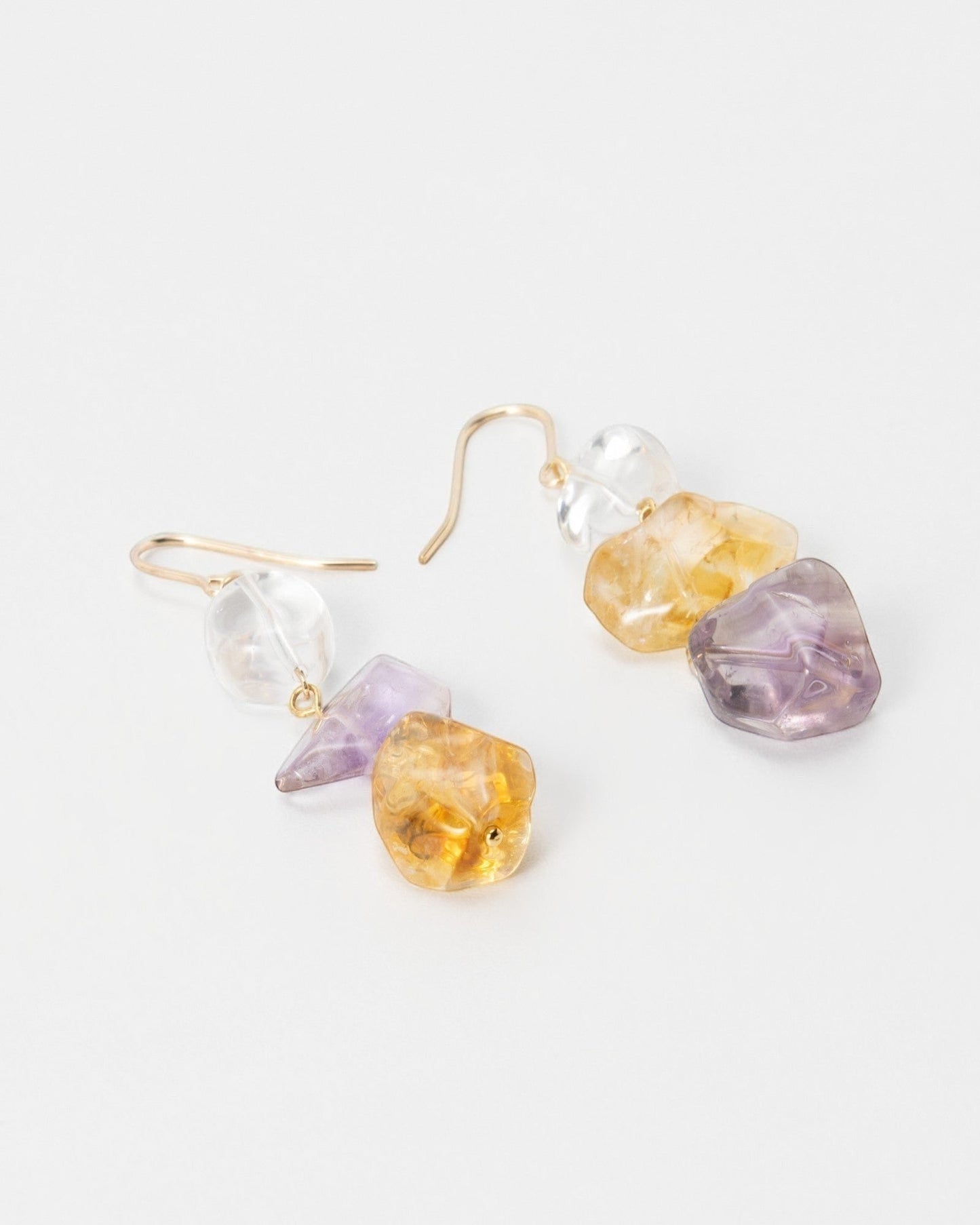 Elsita Jewelry Raw earrings featuring dangling rough-cut citrine, amethyst, and clear quartz stones on gold hooks.