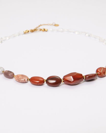 Elsita Jewelry Glow necklace featuring a gradient of red agate, picture jasper, and clear quartz beads on a white background.