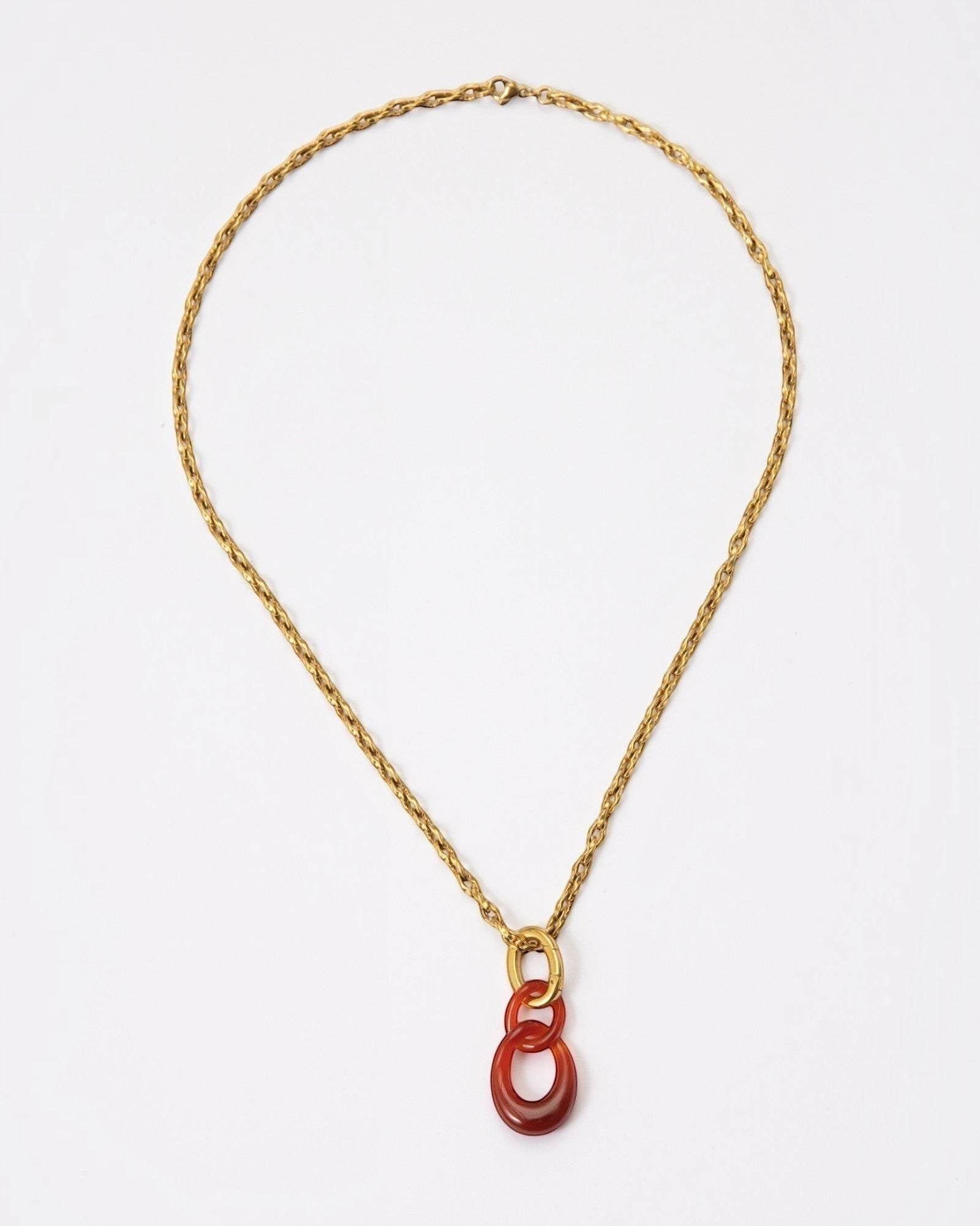 Elsita Jewelry Link Red necklace featuring a hand-carved red agate interlocked chain pendant on a gold-tone chain.