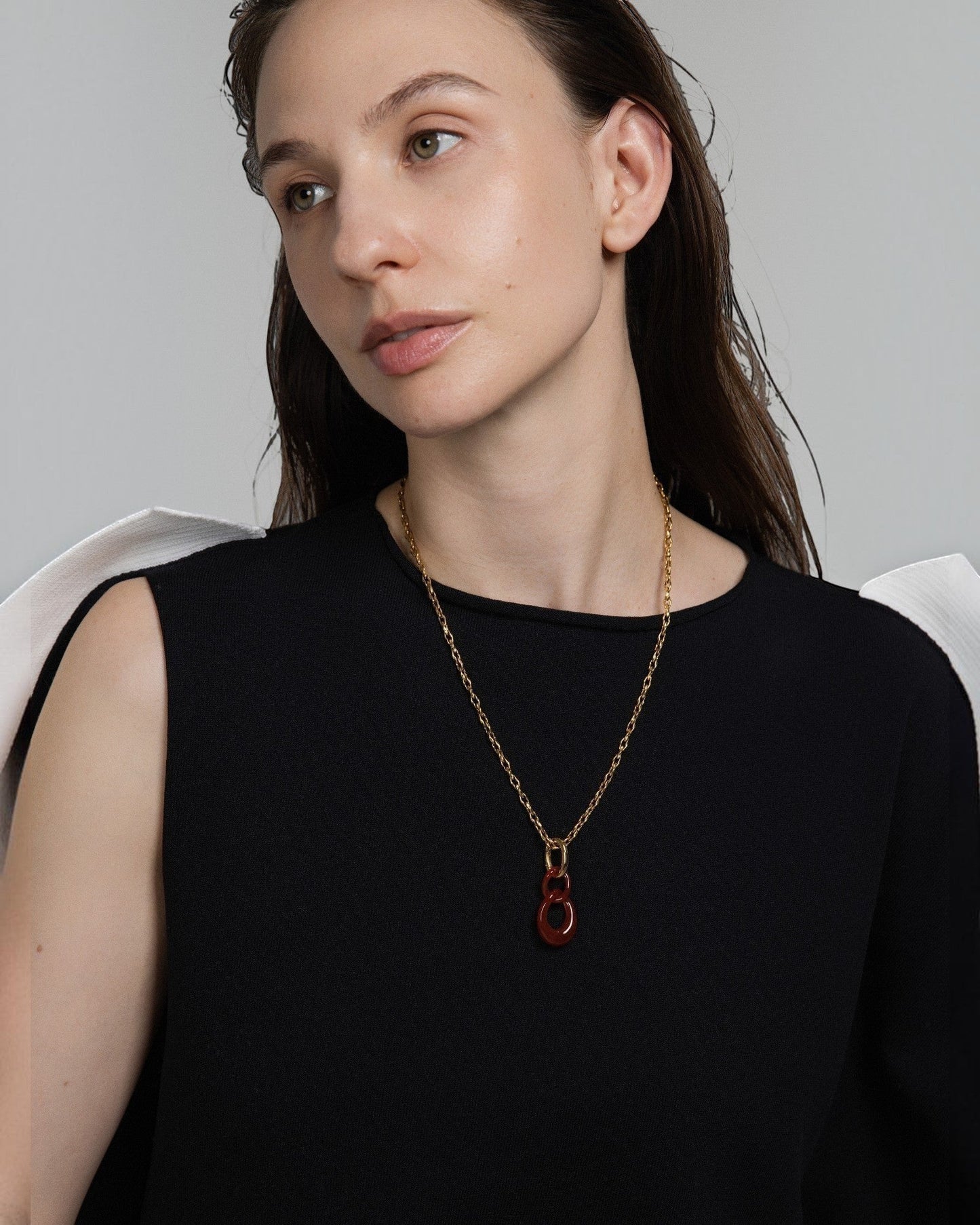 Elsita Jewelry Link Red necklace featuring a hand-carved red agate interlocked chain pendant on a gold-tone chain.