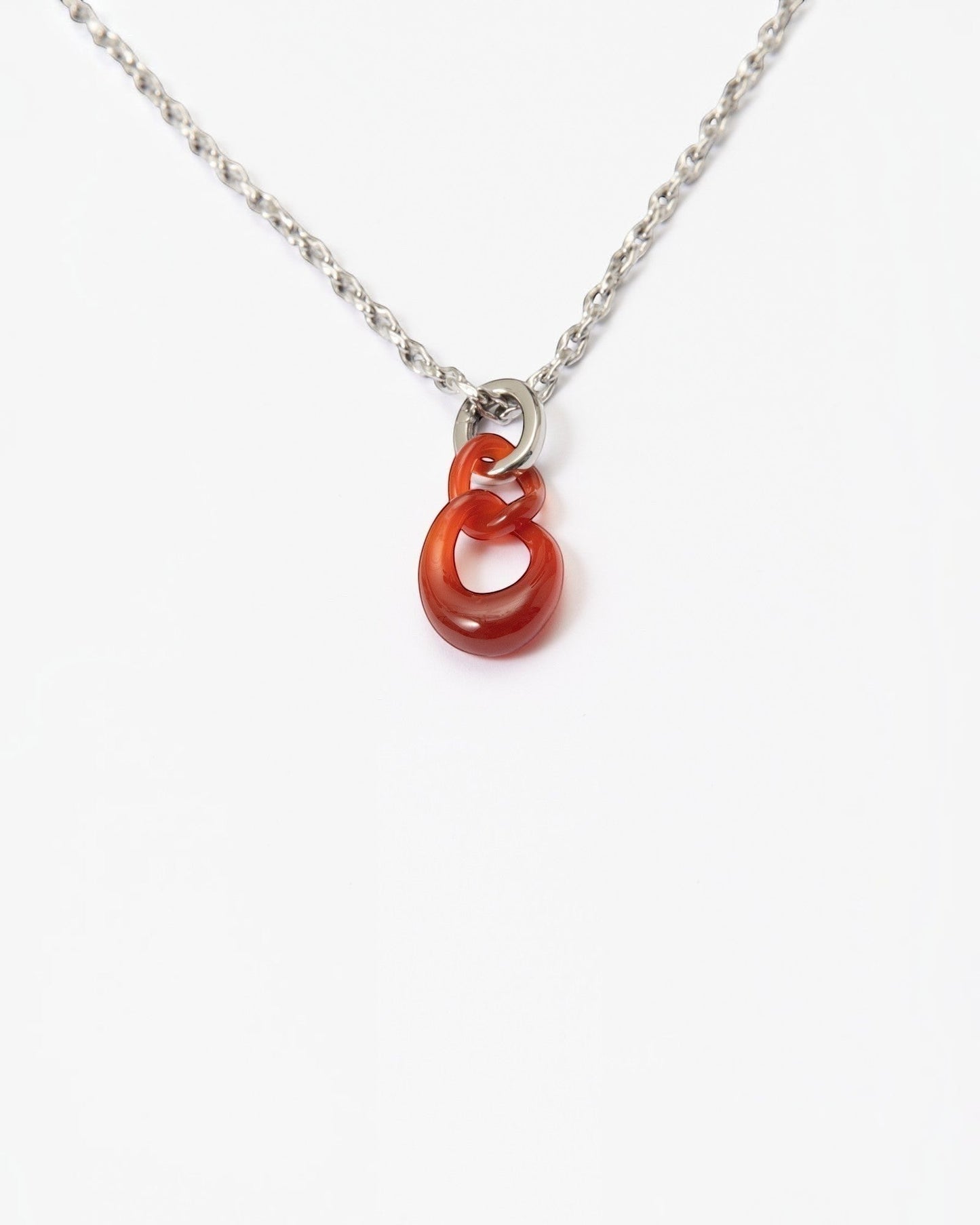 Elsita Jewelry Link Red necklace featuring two hand-carved interlocked red agate stone chain links on a silver chain.