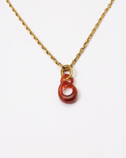 Elsita Jewelry Link Red necklace featuring a hand-carved red agate interlocked chain pendant on a gold-tone chain.