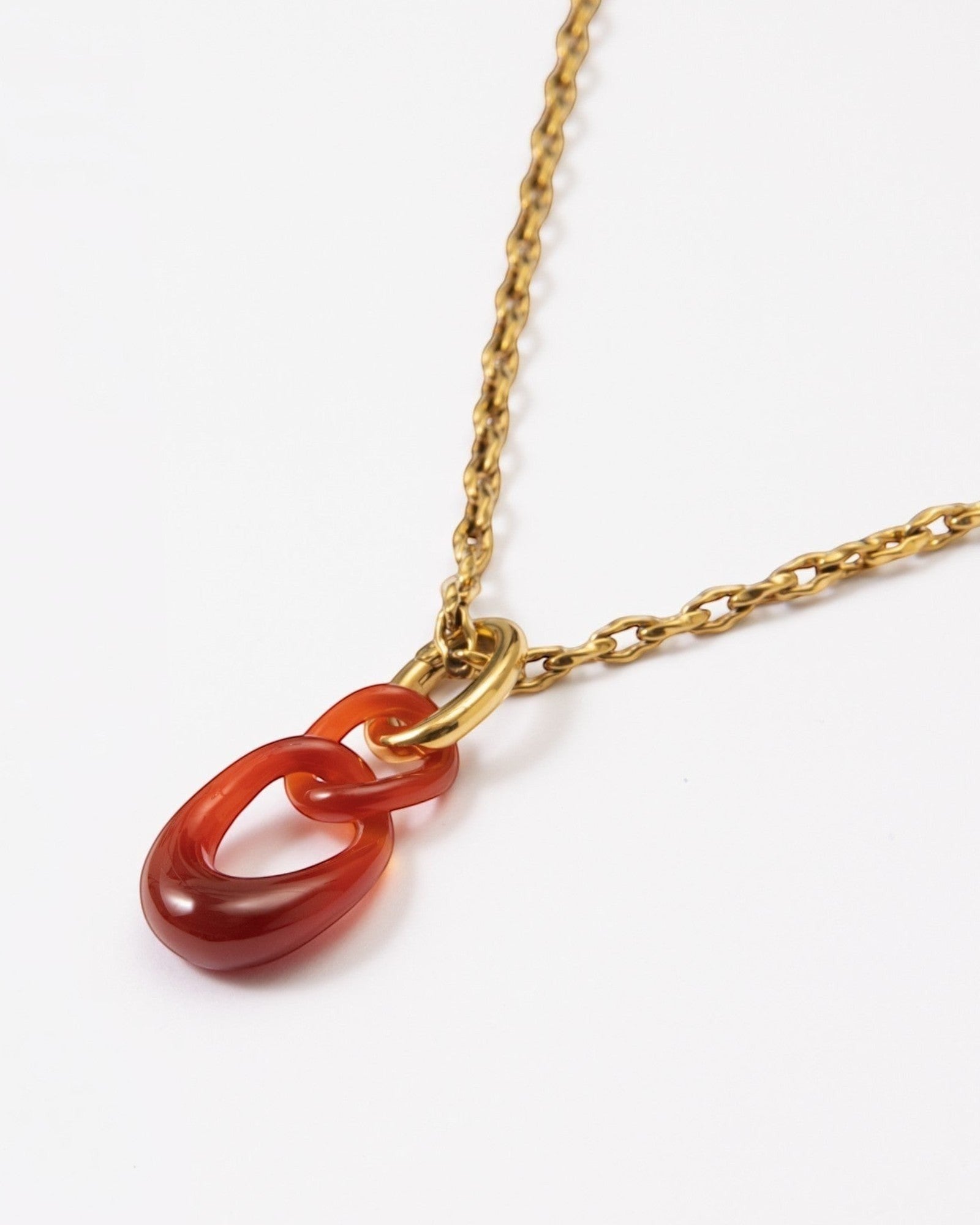 Elsita Jewelry Link Red necklace featuring a hand-carved red agate interlocked chain pendant on a gold-tone chain.