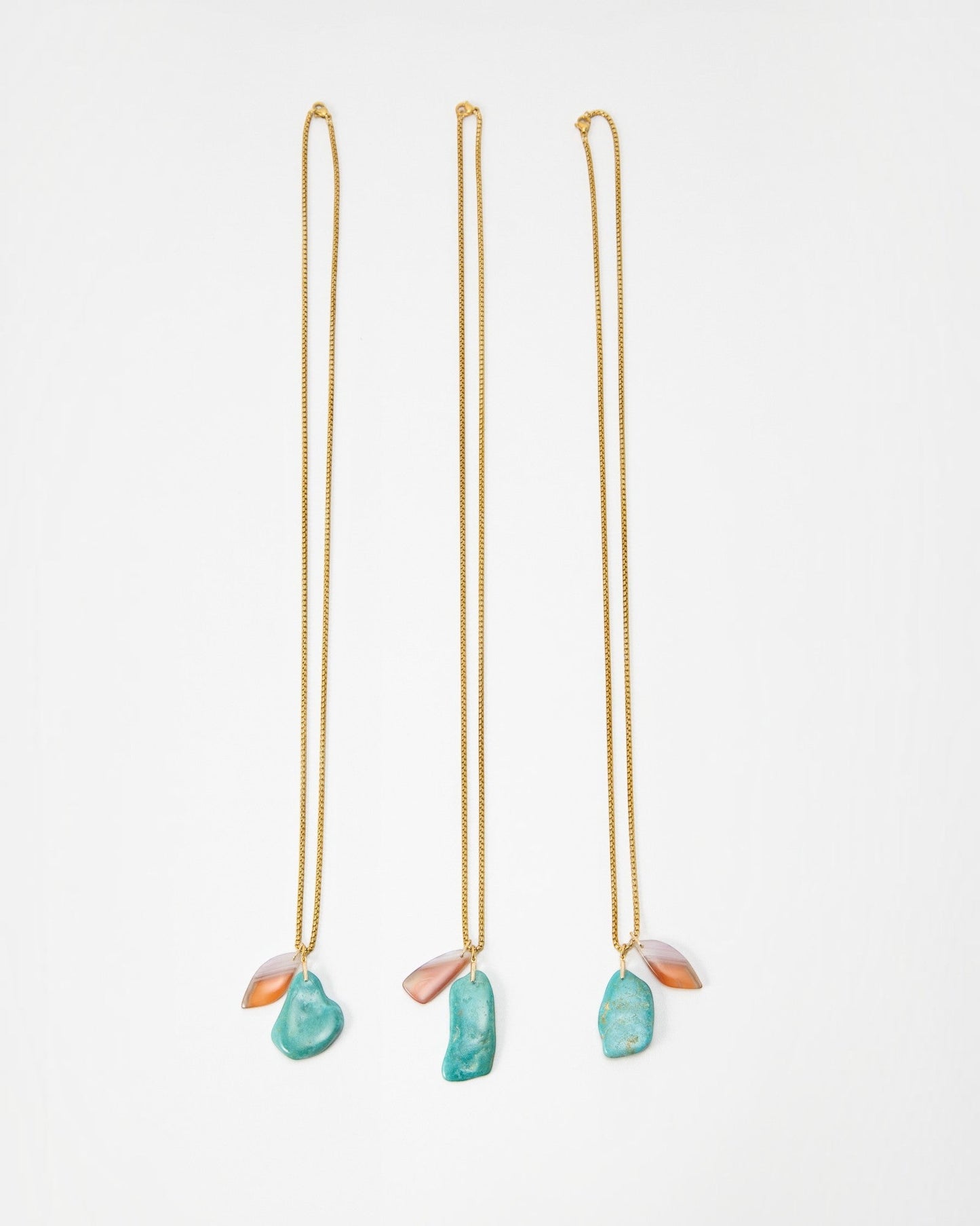 Elsita Jewelry Rusty I necklaces featuring gold chains with dangling turquoise and orange stone pendants