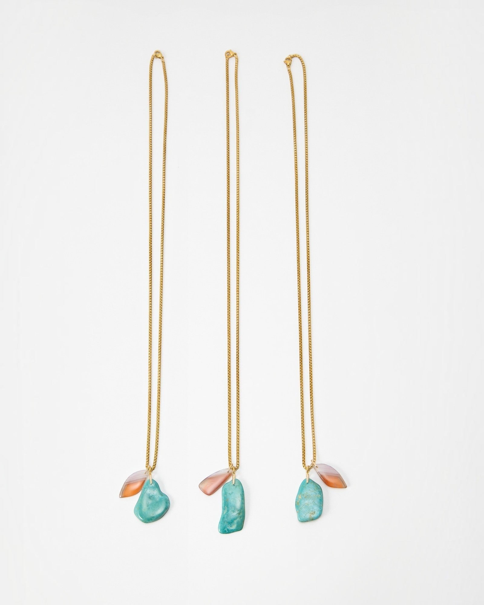 Elsita Jewelry Rusty III gold chain necklaces featuring raw turquoise and translucent peach stone pendants