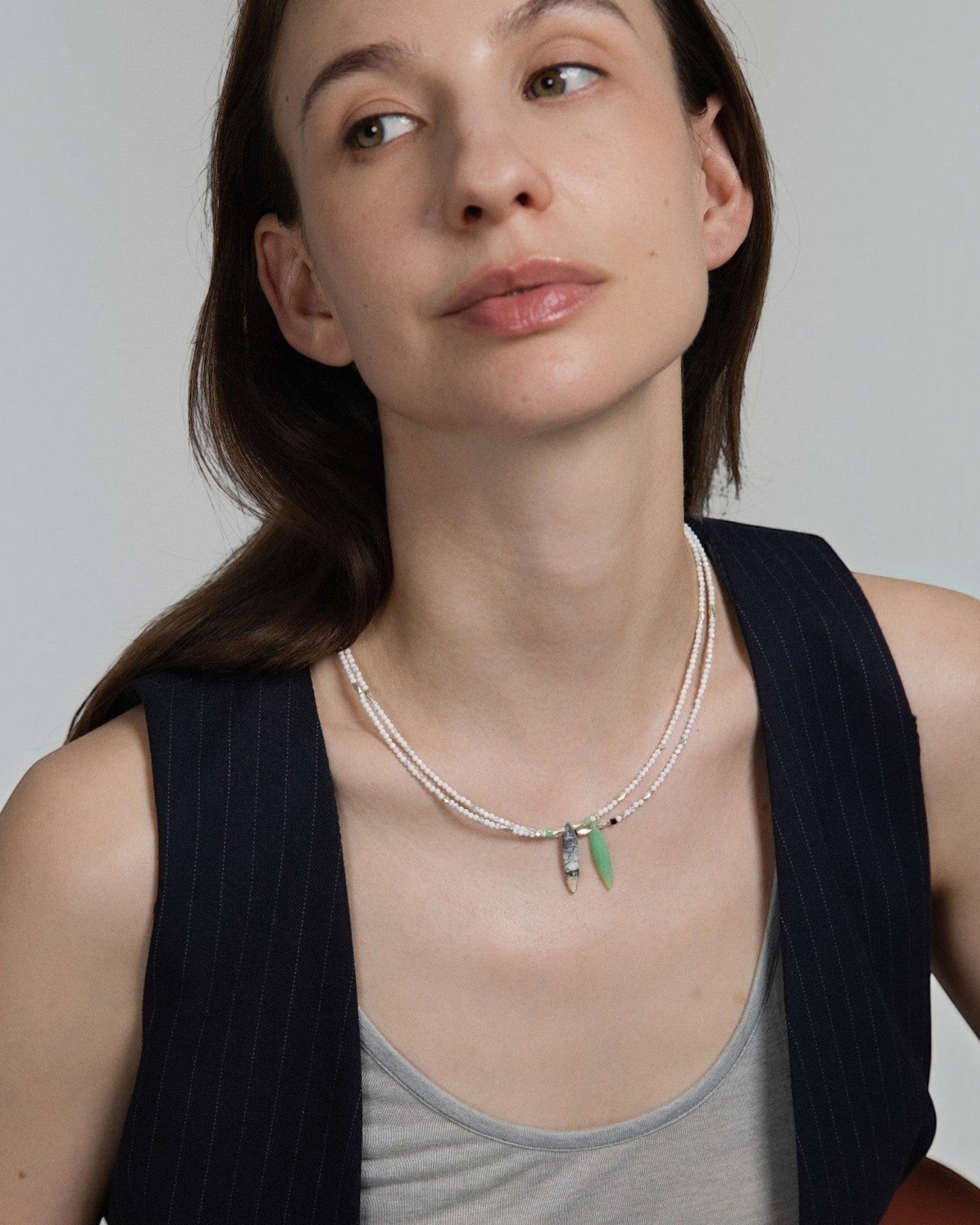 Elsita Jewelry Snowline Grey necklace featuring white howlite, grey agate, and green chrysoprase on a model.
