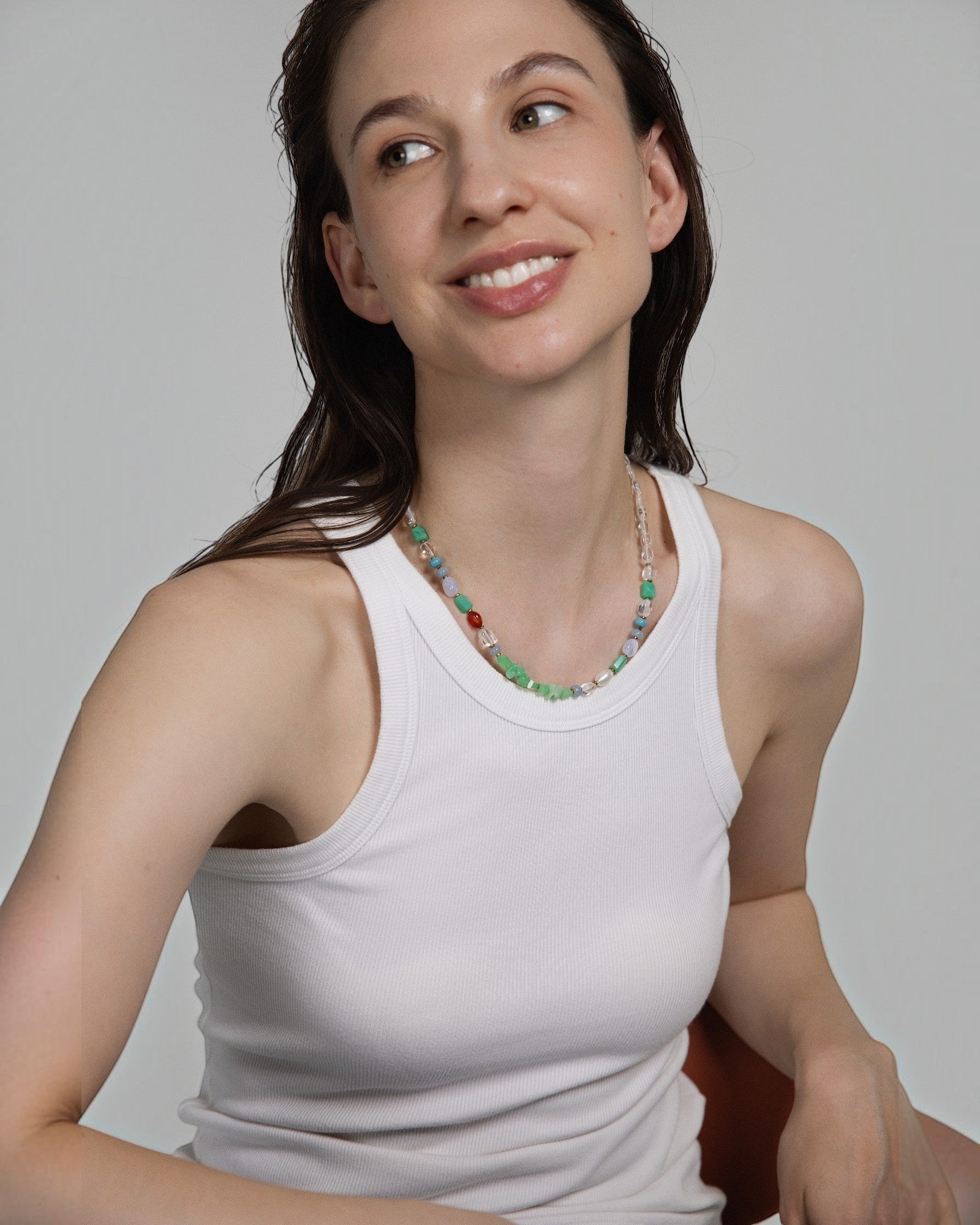 Elsita Jewelry Spring necklace featuring colorful chrysoprase, pearl, and mineral beads worn by a smiling woman.