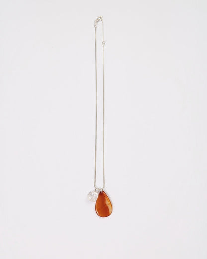 Elsita Jewelry Soda II necklace featuring a teardrop red agate and clear quartz pendant on a sterling silver chain.