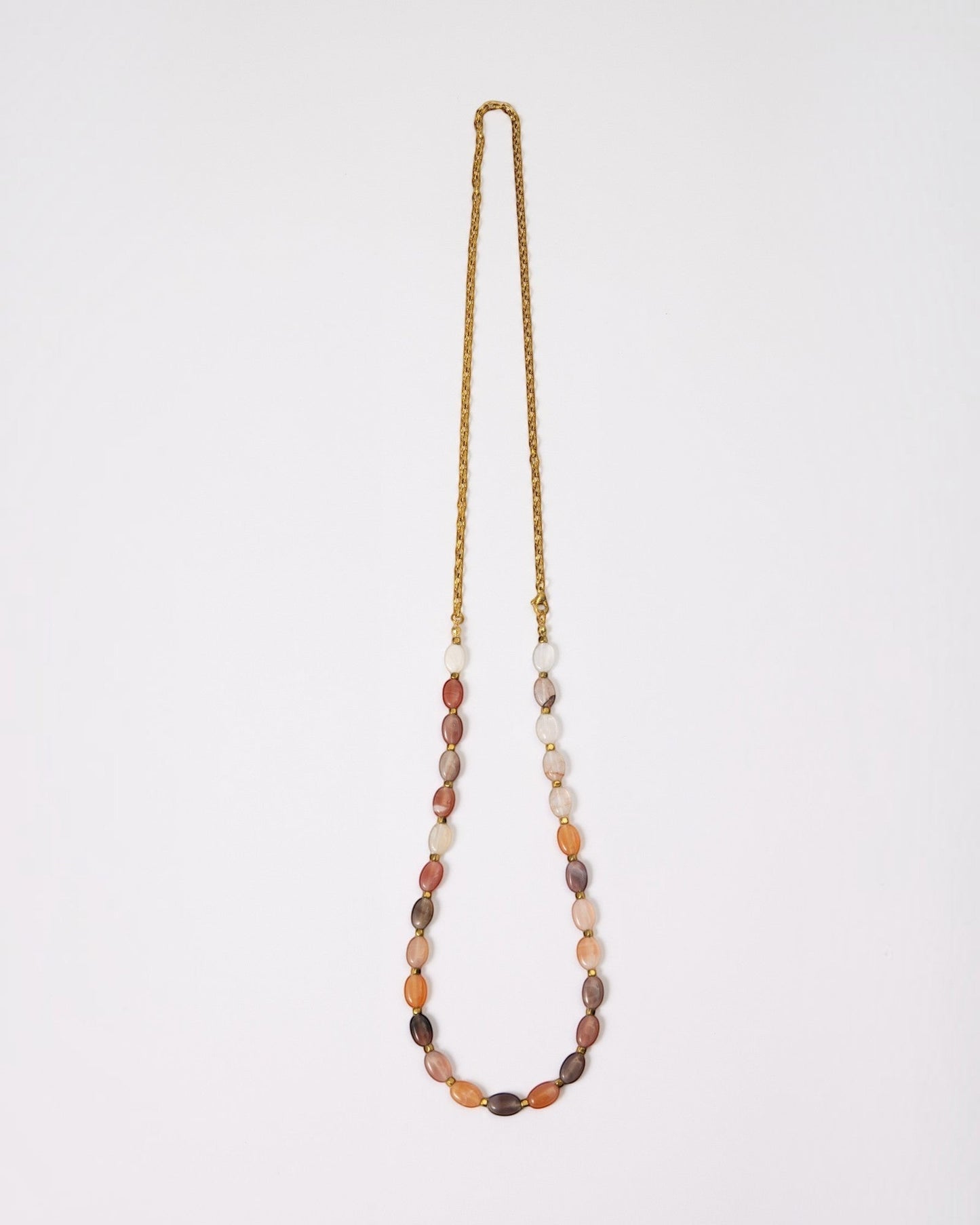 Elsita Jewelry Terrain long necklace featuring oval mixed agate stones in earth tones with a gold-tone chain.
