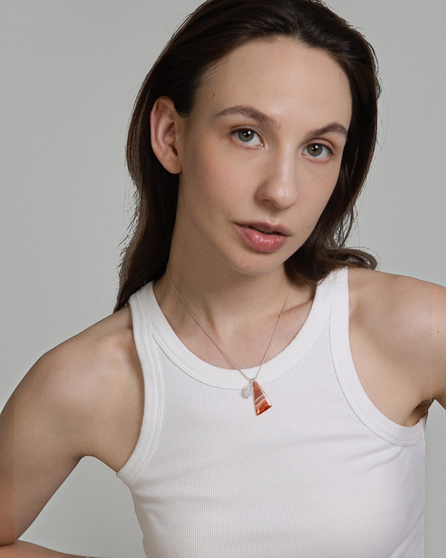 Model wearing Elsita Jewelry Soda III triangular red agate and clear quartz pendant on a sterling silver snake chain.