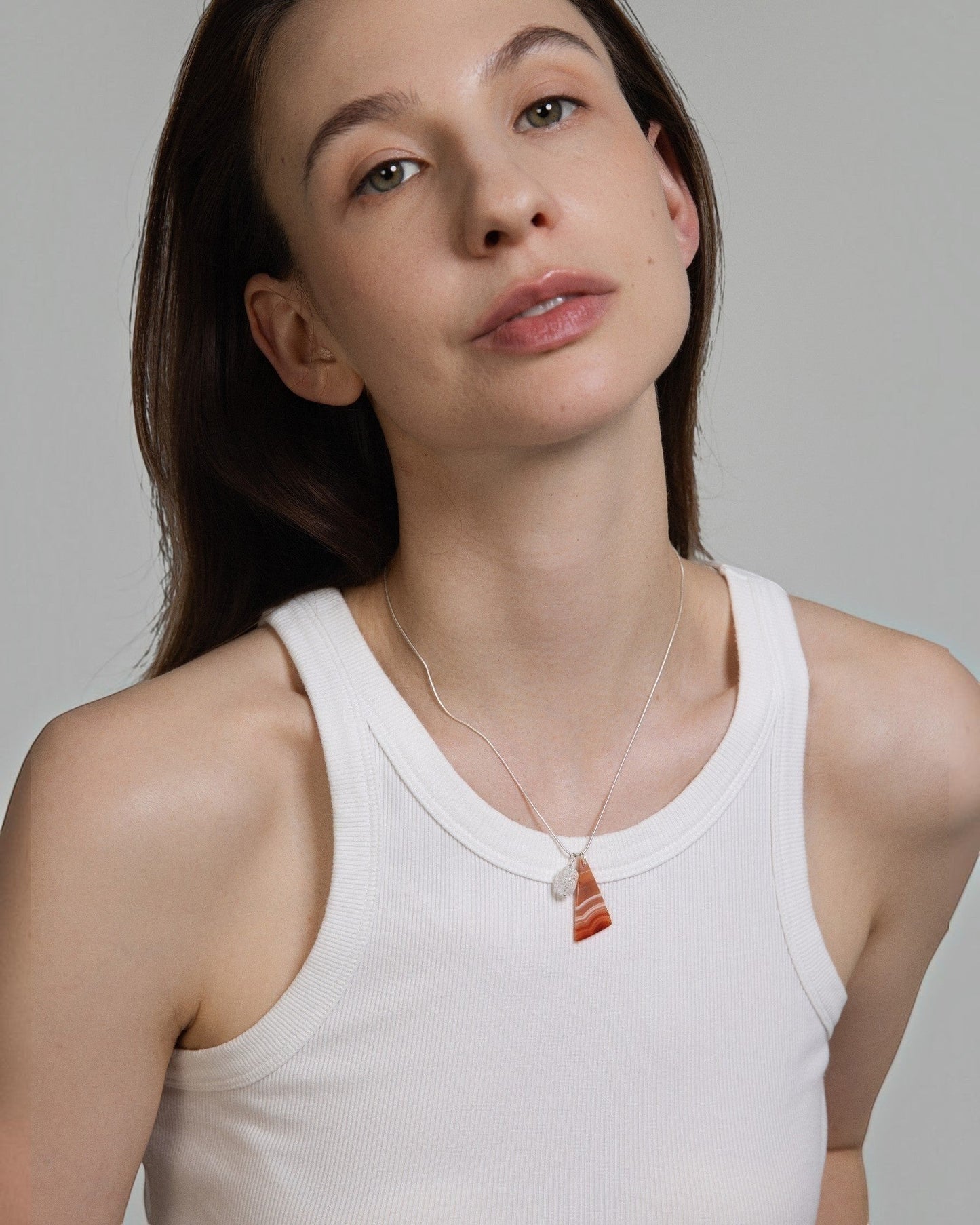 Model wearing Elsita Jewelry Soda III triangular red agate and clear quartz pendant necklace on sterling silver chain