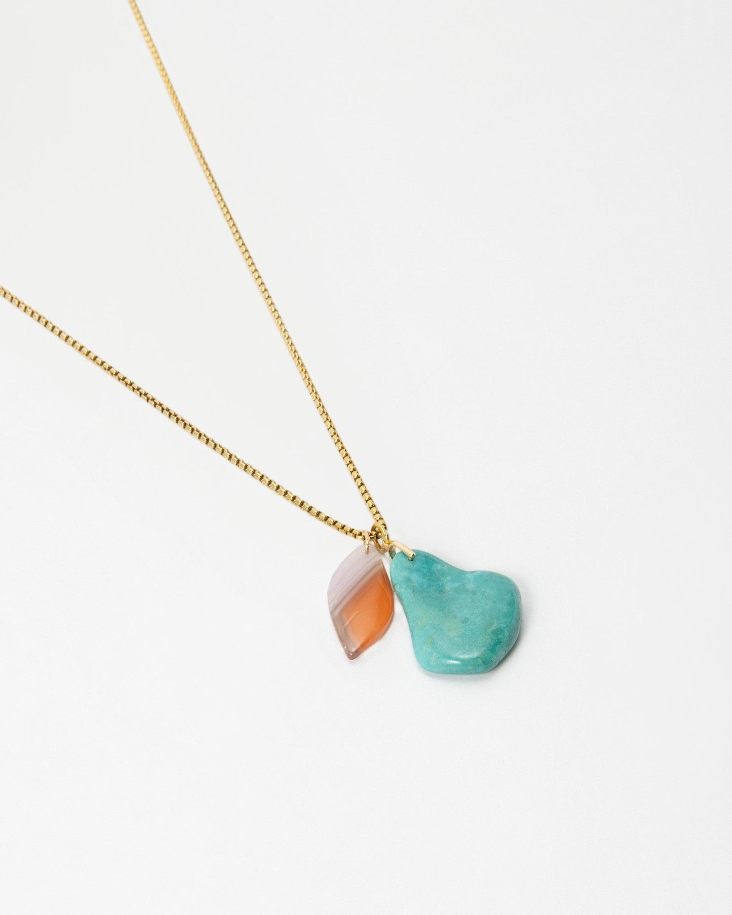 Elsita Jewelry Rusty III necklace featuring a gold chain with a turquoise stone and a small orange agate charm