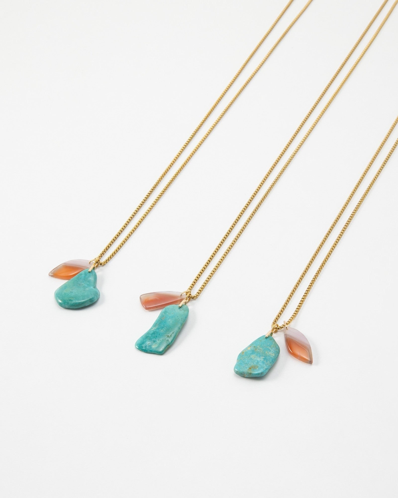 Elsita Jewelry Rusty III gold chain necklaces featuring raw turquoise and teardrop carnelian stone pendants